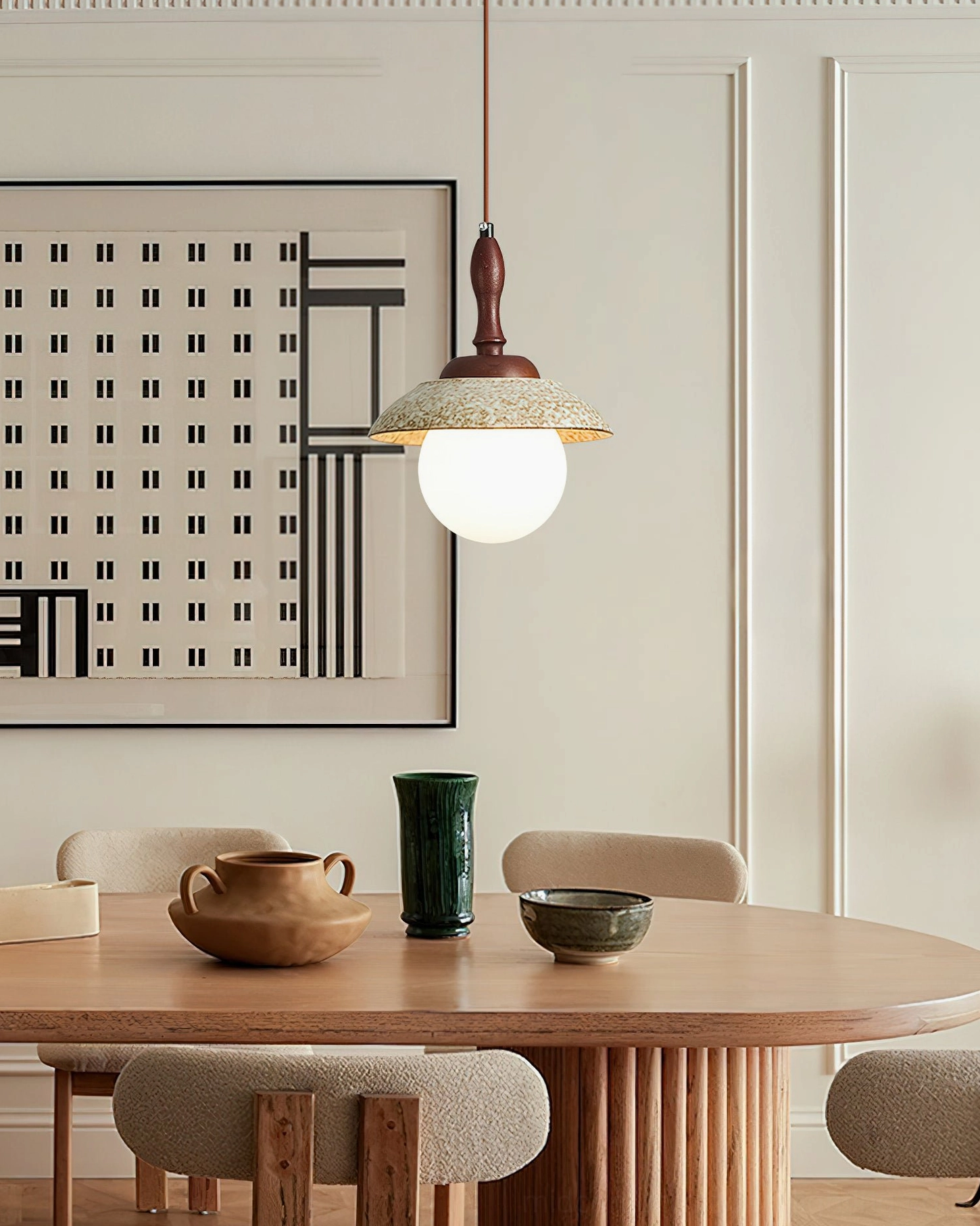 Humboldt pendant light with light yellow shade above modern round wooden dining table