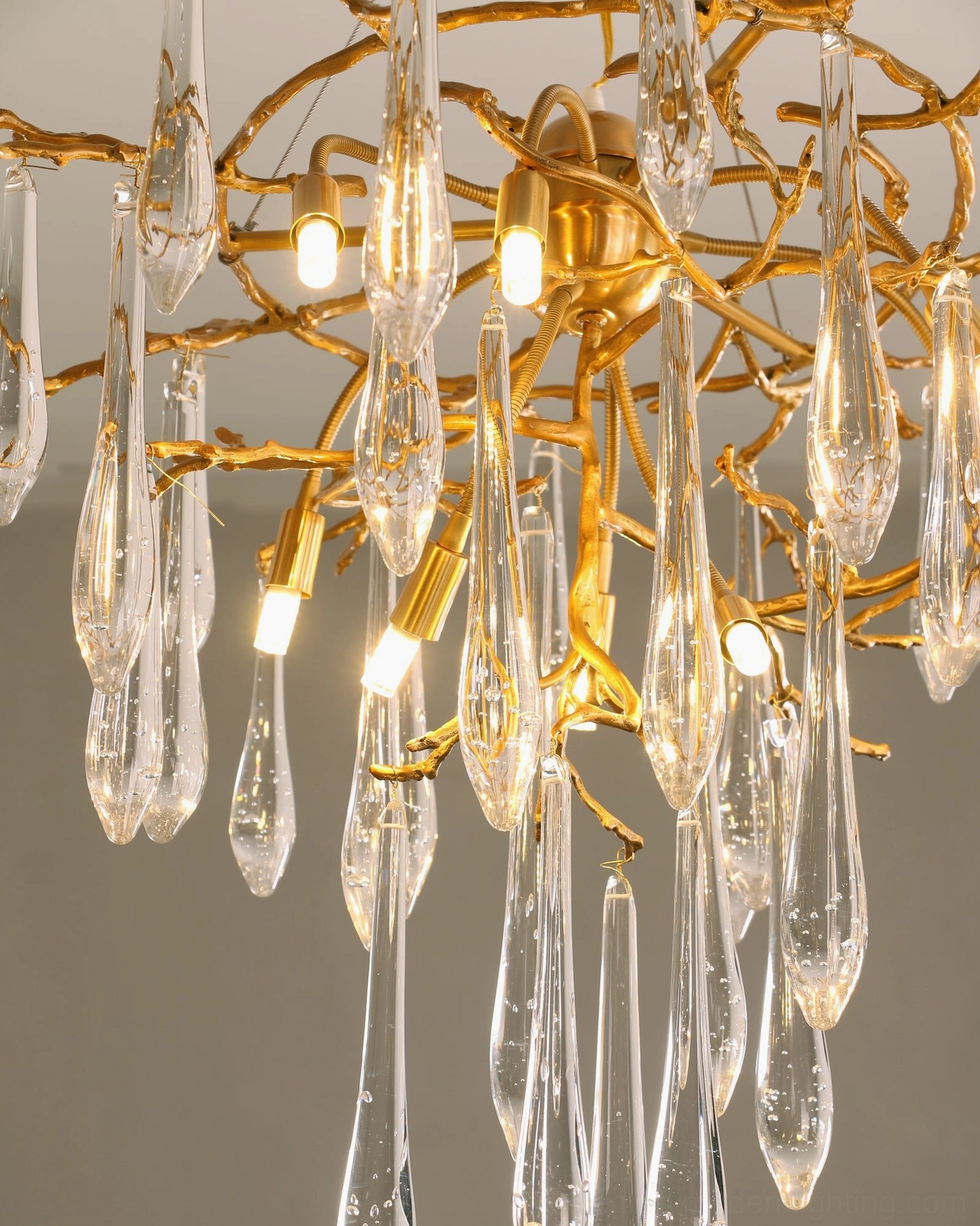 Close-up detail of brass icicle crystal pendant showing warm bulbs and teardrop crystal pendants
