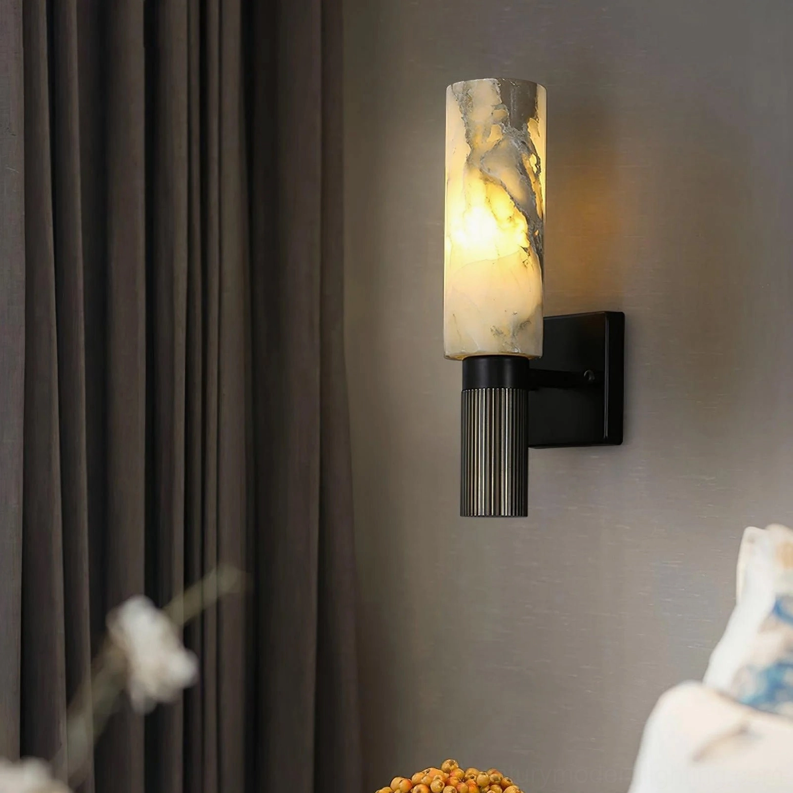 Illuminated alabaster cylinder wall lamp demonstrating warm light diffusion and interior ambiance creation