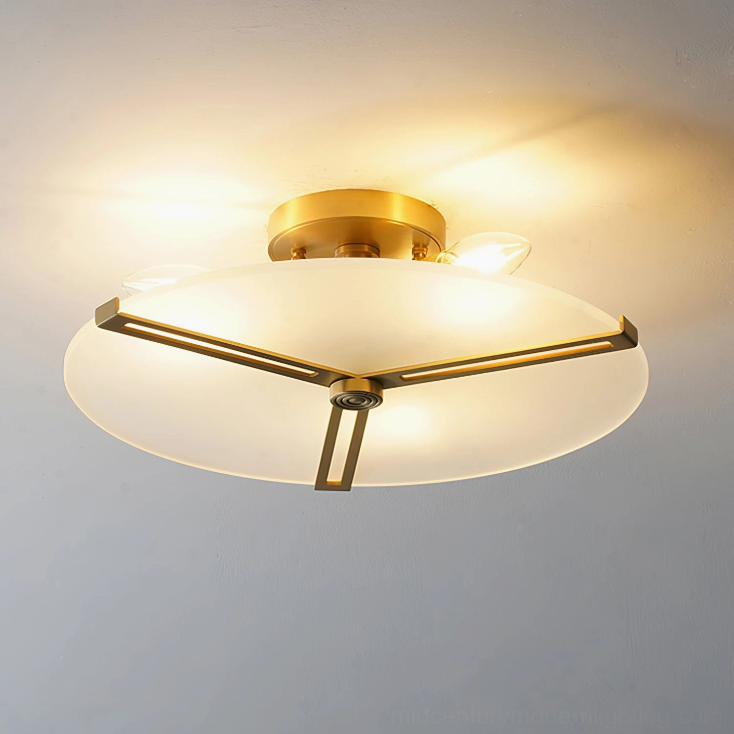 Illuminated geometric brass ceiling lamp in contemporary interior design setting