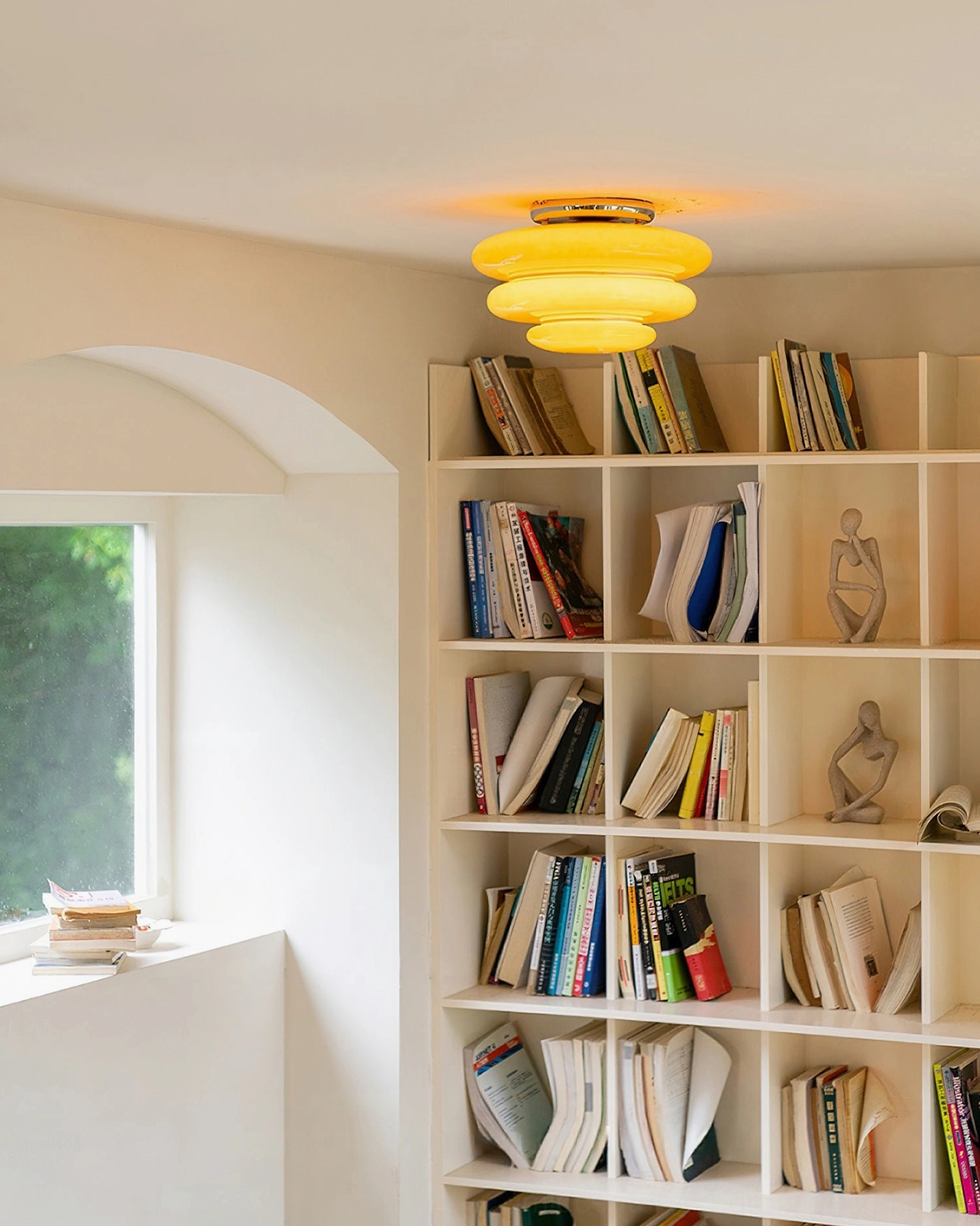 Illuminated orange tiered ceiling lamp warm glow home library background