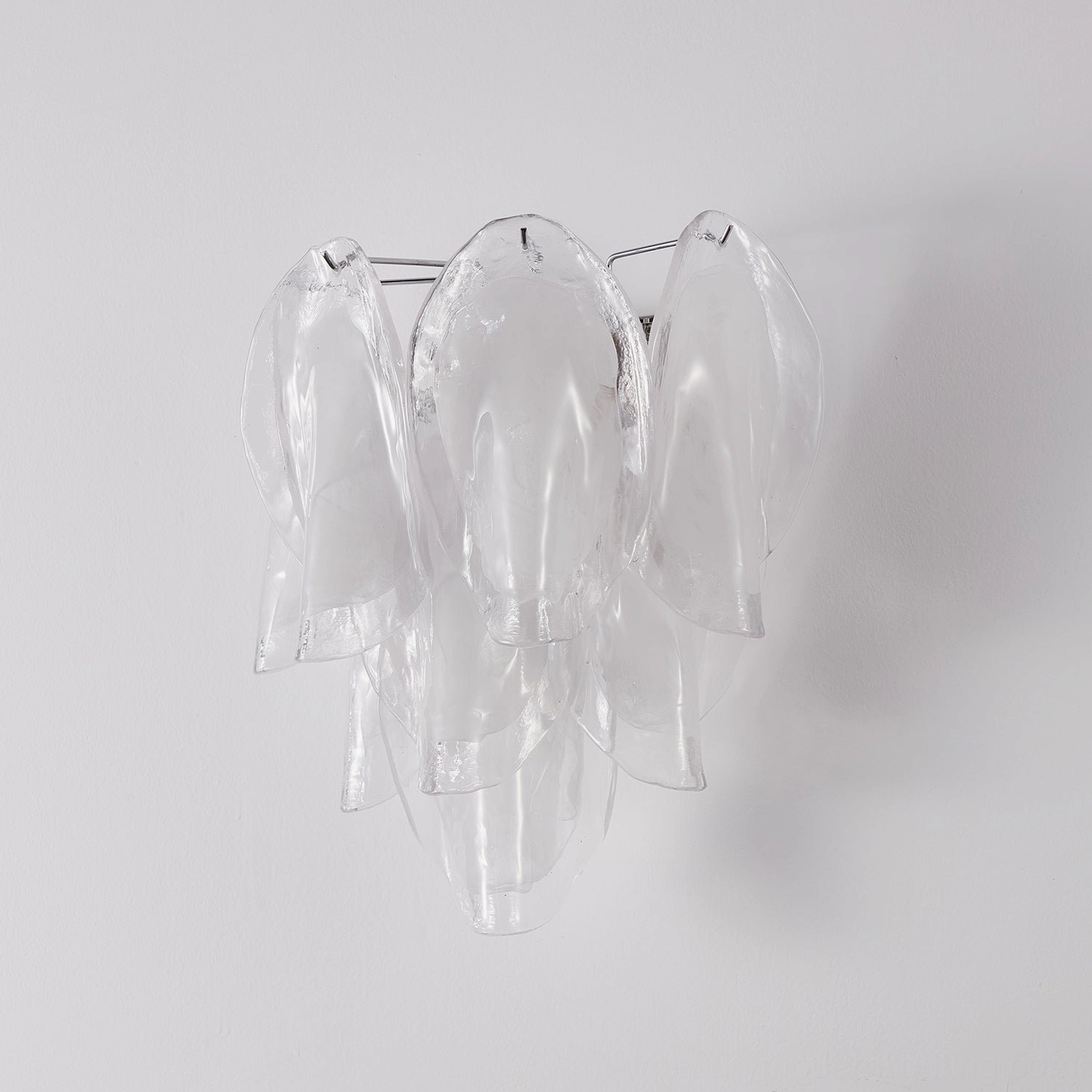 Ina glass wall light showing drooping elegant petal form and sculptural architecture