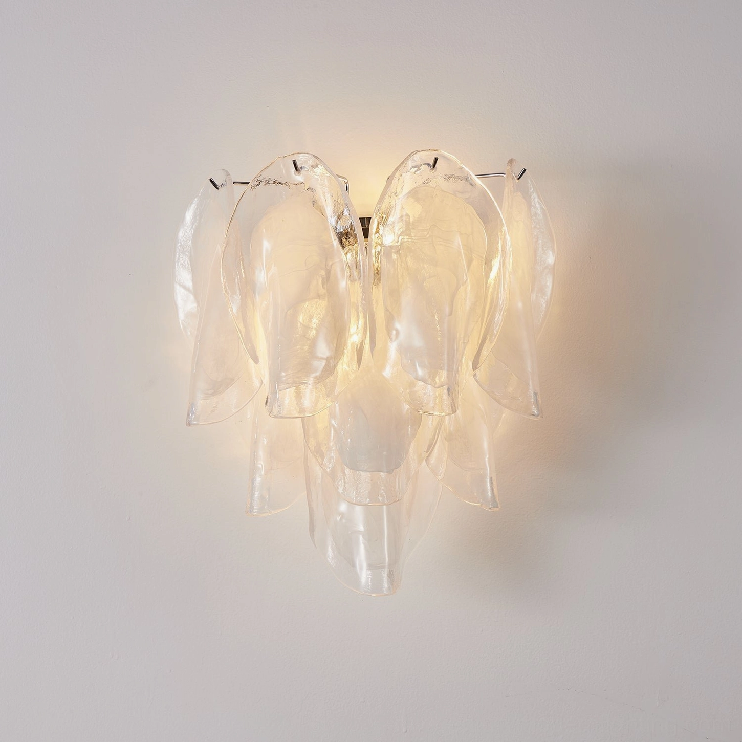 Ina modern glass petal sconce lit showing ethereal warm glow and light diffusion