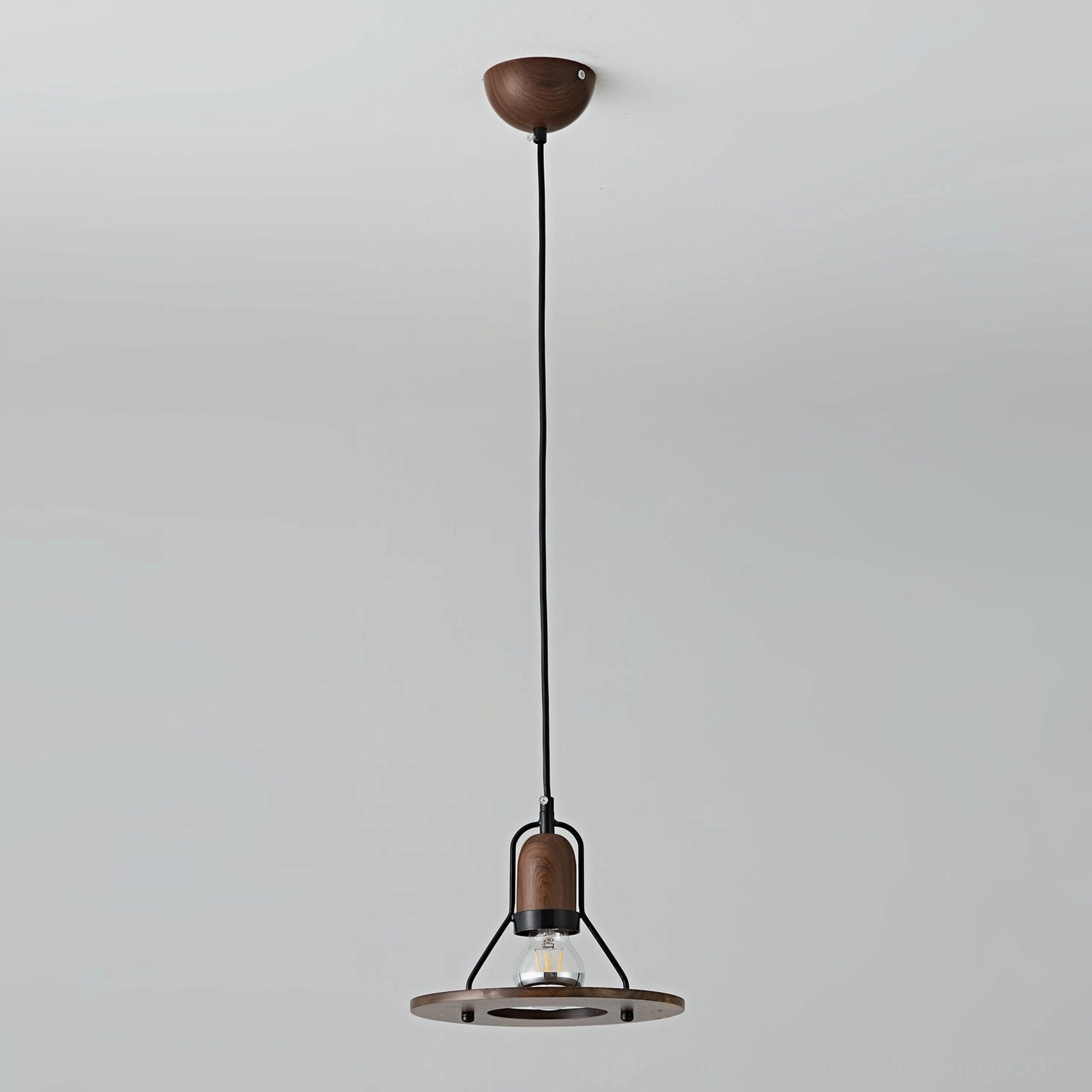 Industrial black pendant lamp with extended suspension cord, overhead studio view emphasizing geometric form