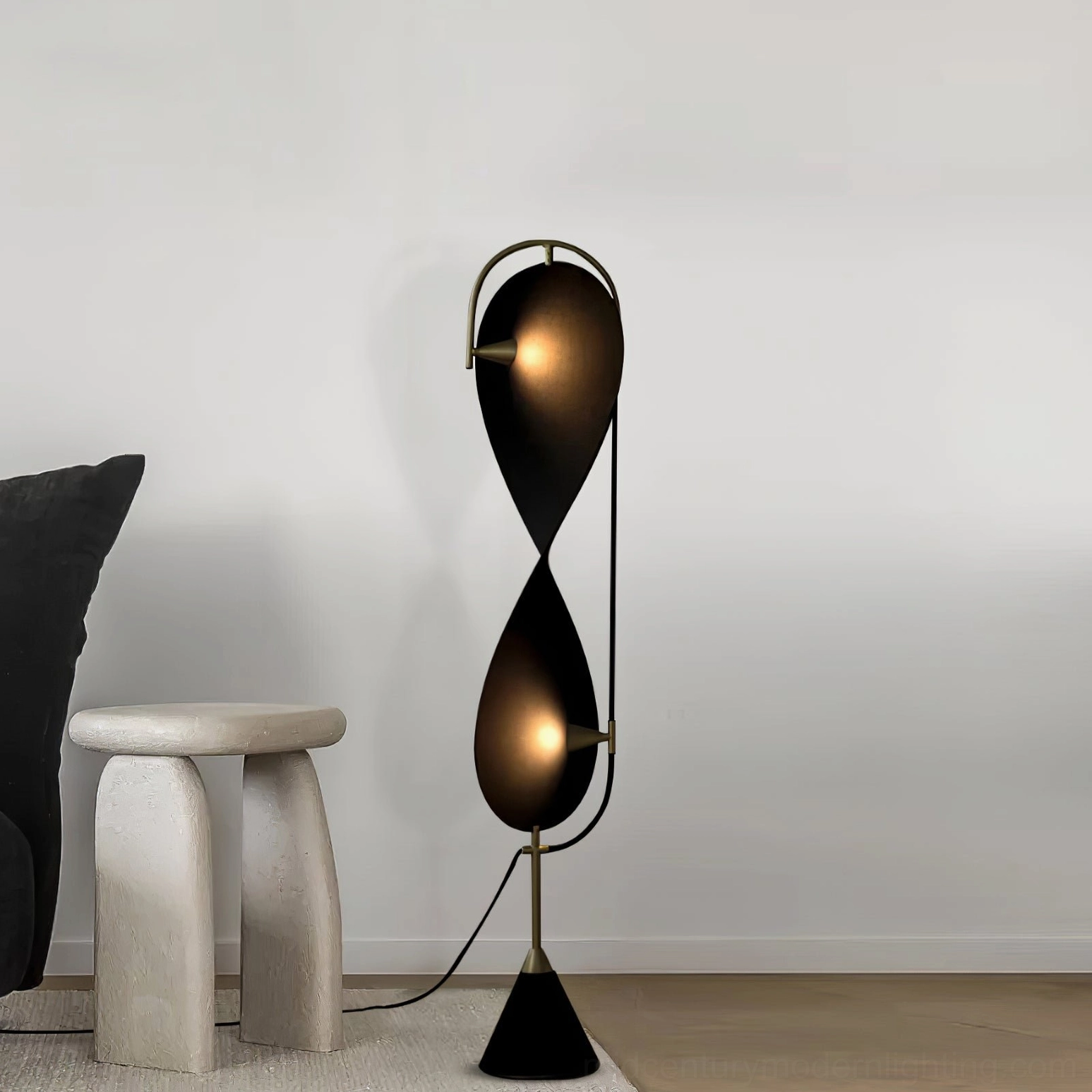 Front view of Infinite Floor Lamp showing clean black and gold design, soft warm lighting in bright neutral minimalist space