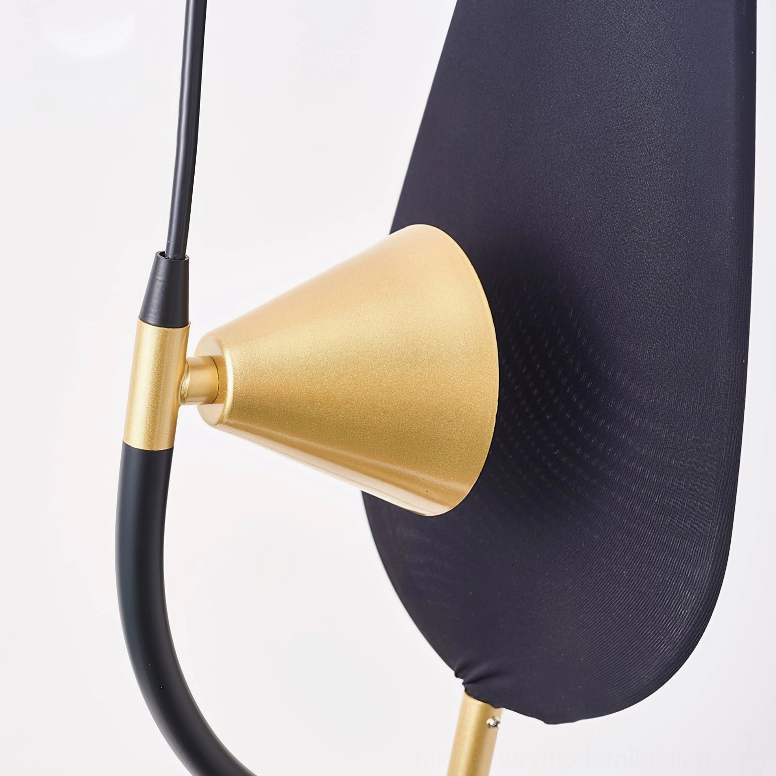 Close-up macro detail of Infinite Floor Lamp head showing matte brass gold finish and black fabric shade construction