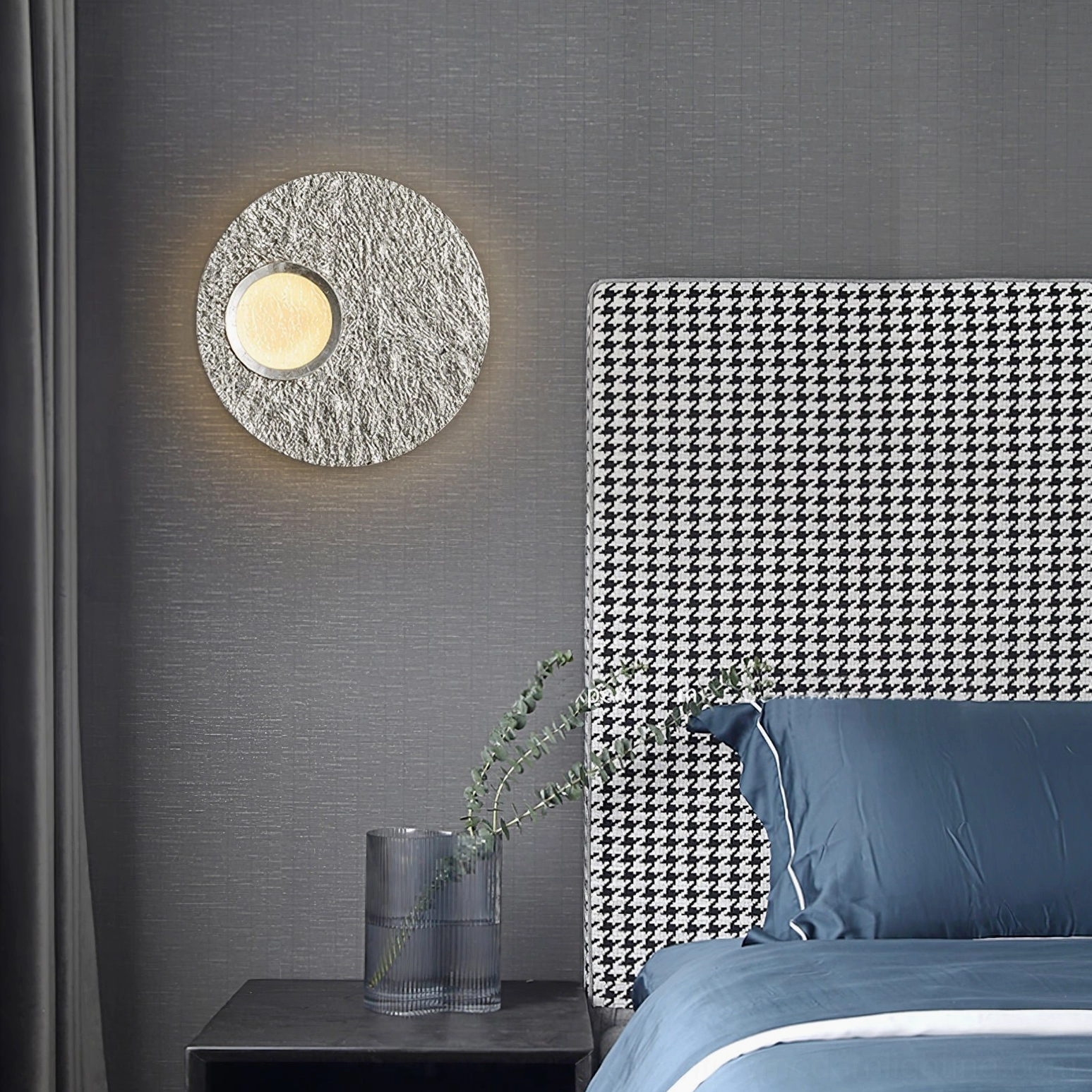 Silver Infinity LED wall lamp installed above minimalist houndstooth headboard in contemporary master bedroom