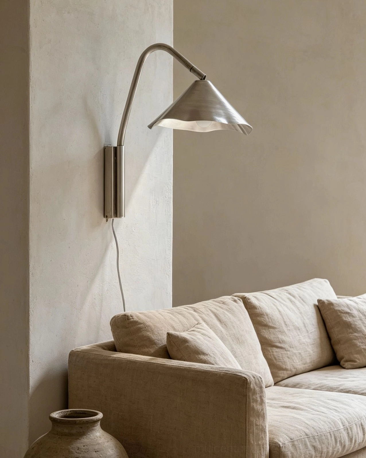 Janna brushed nickel sconce positioned beside modern fabric sofa in contemporary living room