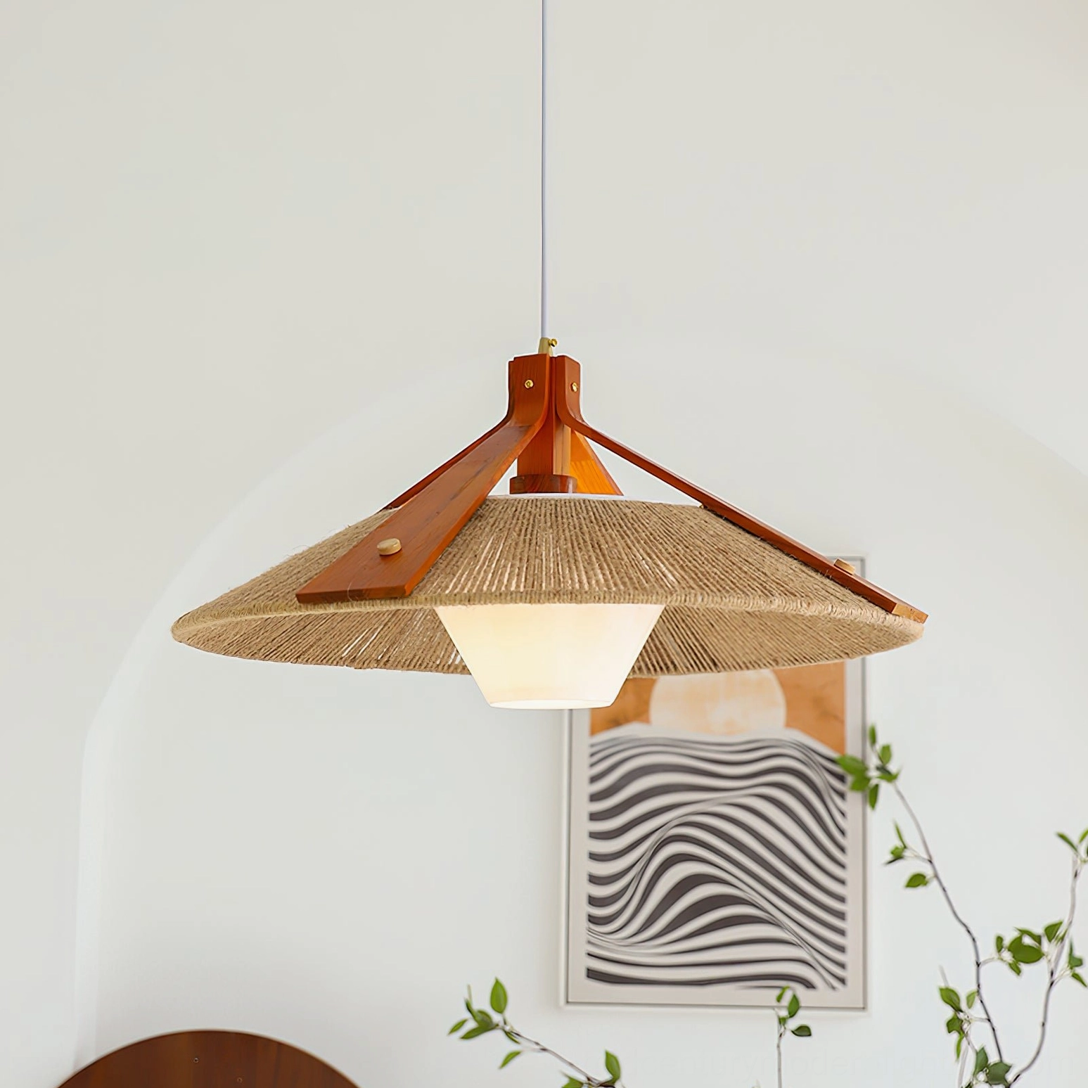 Japandi pendant light installed in contemporary boho living space with arched alcove wall, warm glowing raffia shade and natural wood structure