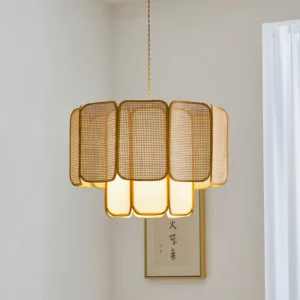 Beige natural rattan Jaras pendant lamp hanging in minimalist corner with wabi-sabi aesthetic and soft warm glow