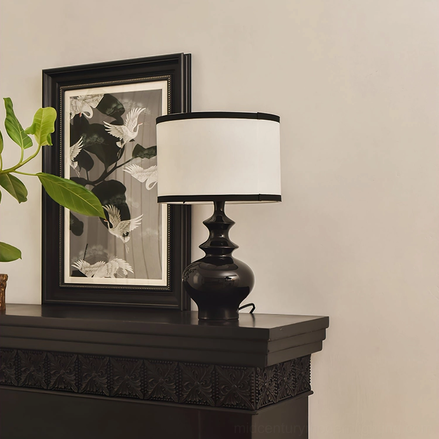 Jarrige ceramic table lamp on elegant black carved fireplace mantel with framed artwork and traditional interior styling