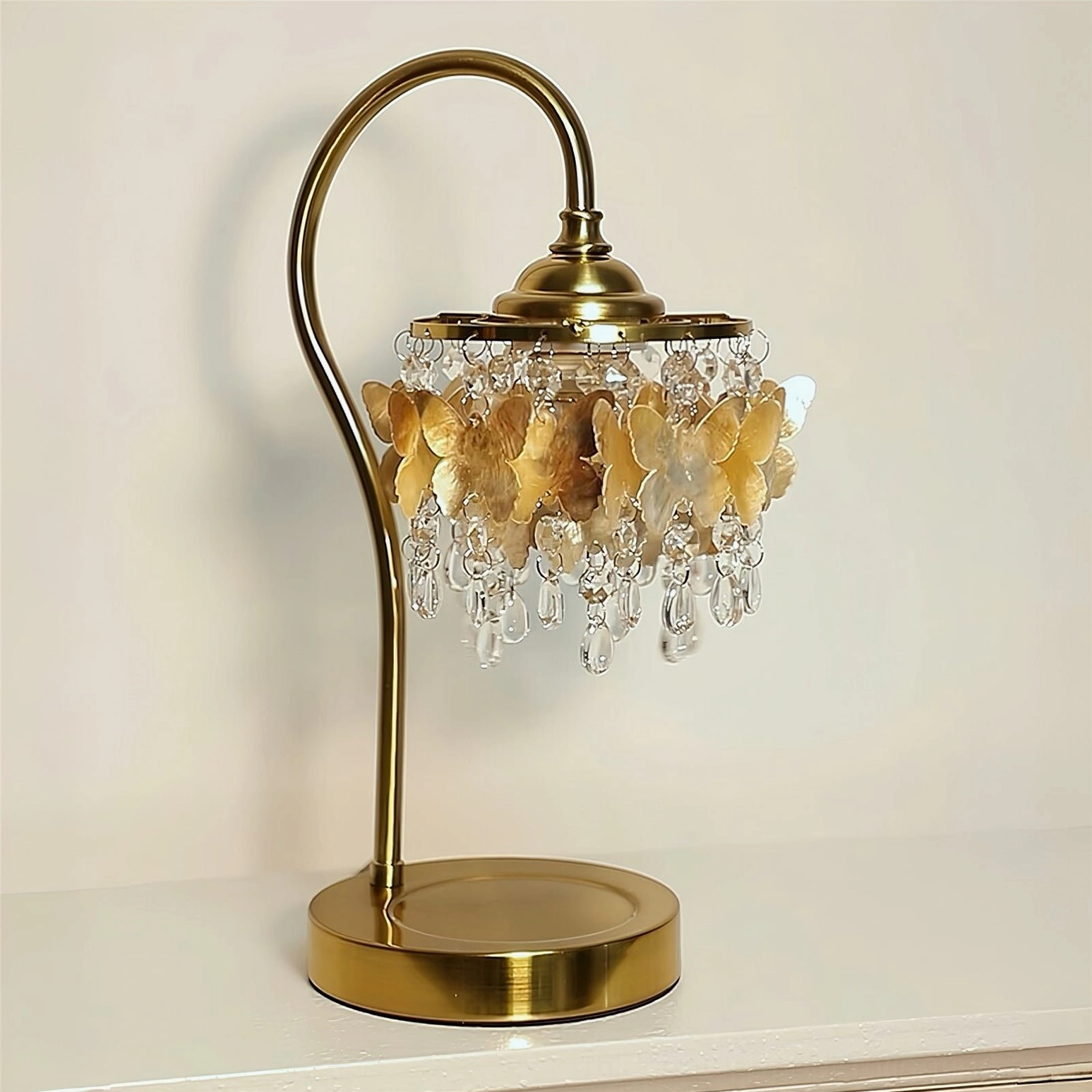Solid brass base and elegant curved metal stand of Jasinski butterfly table lamp on neutral tabletop