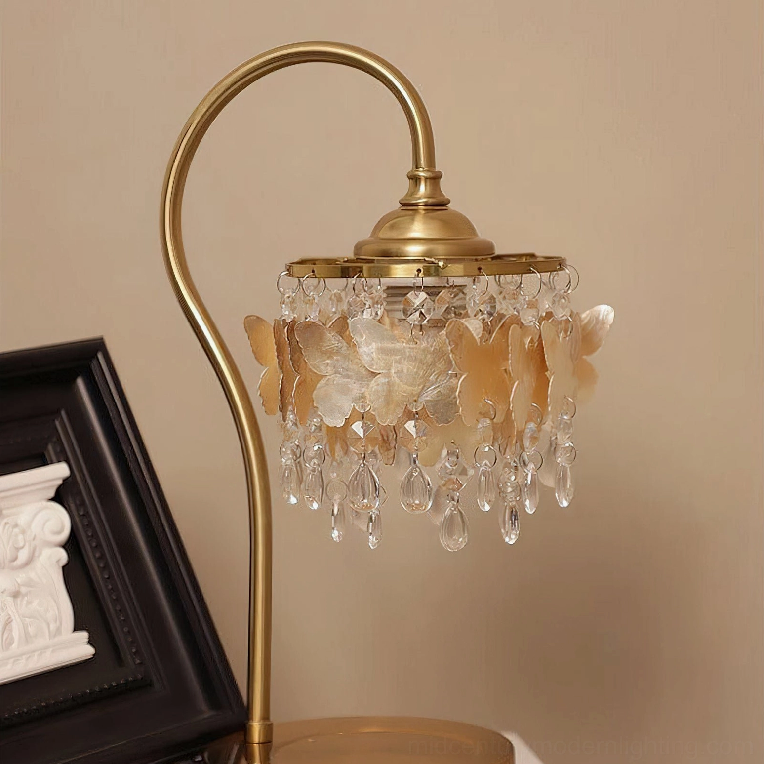 Close-up detail of faceted crystal droplets and polished brass finish on mid-century modern butterfly table lamp