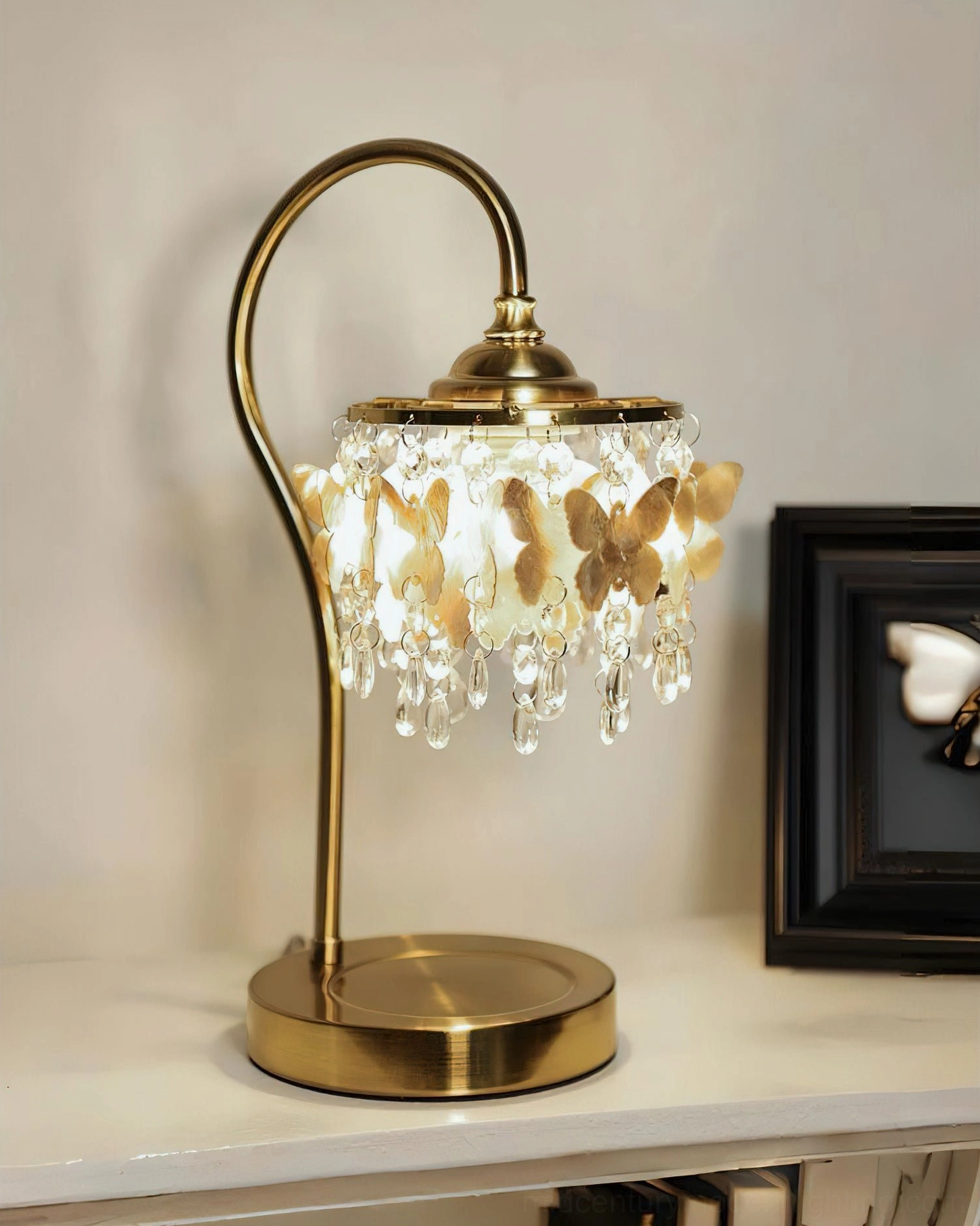 Three-quarter view of illuminated Jasinski butterfly table lamp casting warm glow with crystal light effects