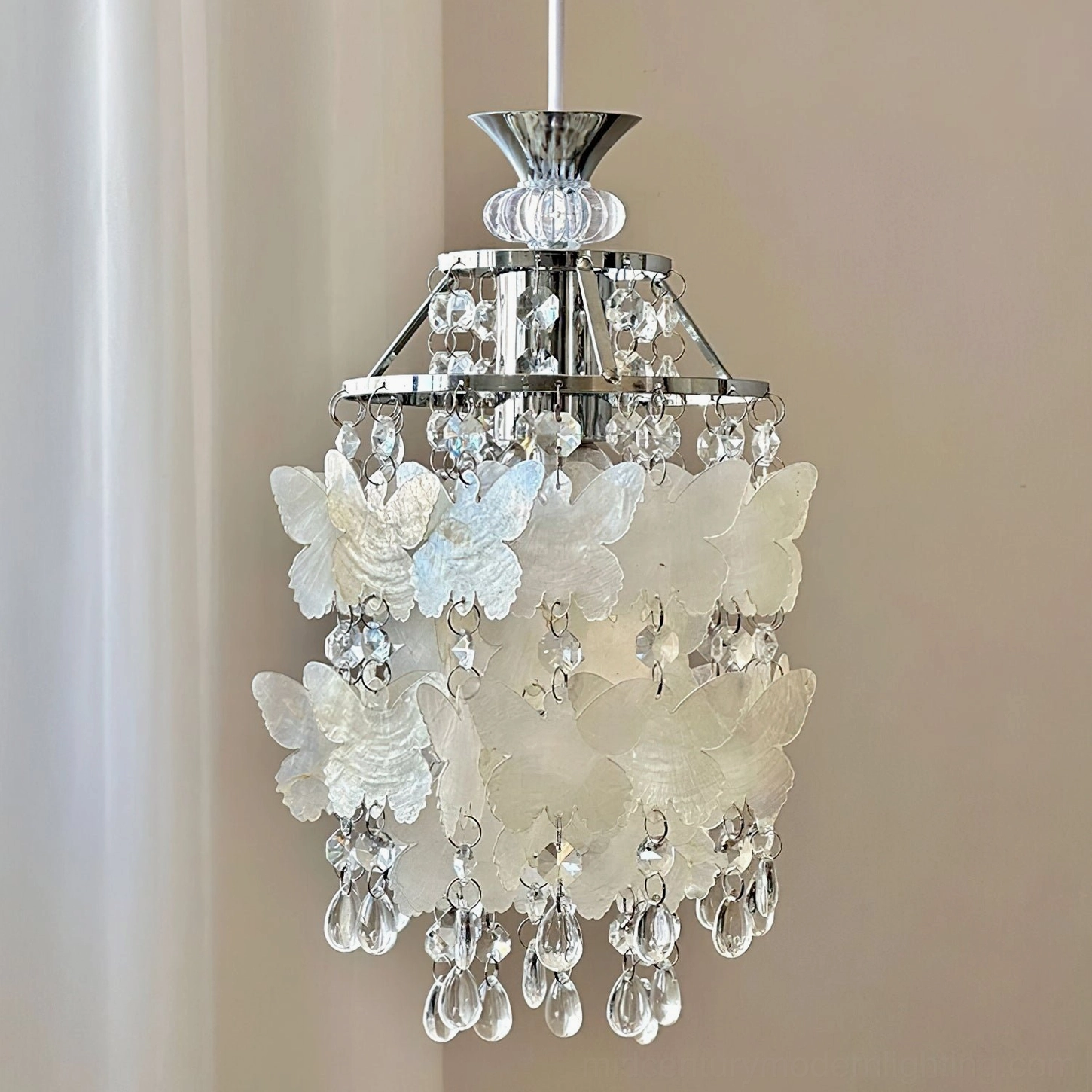 Side close-up detail of Jasinski pendant showing frosted white butterfly decor panels, polished silver hardware and delicate crystal bead chains
