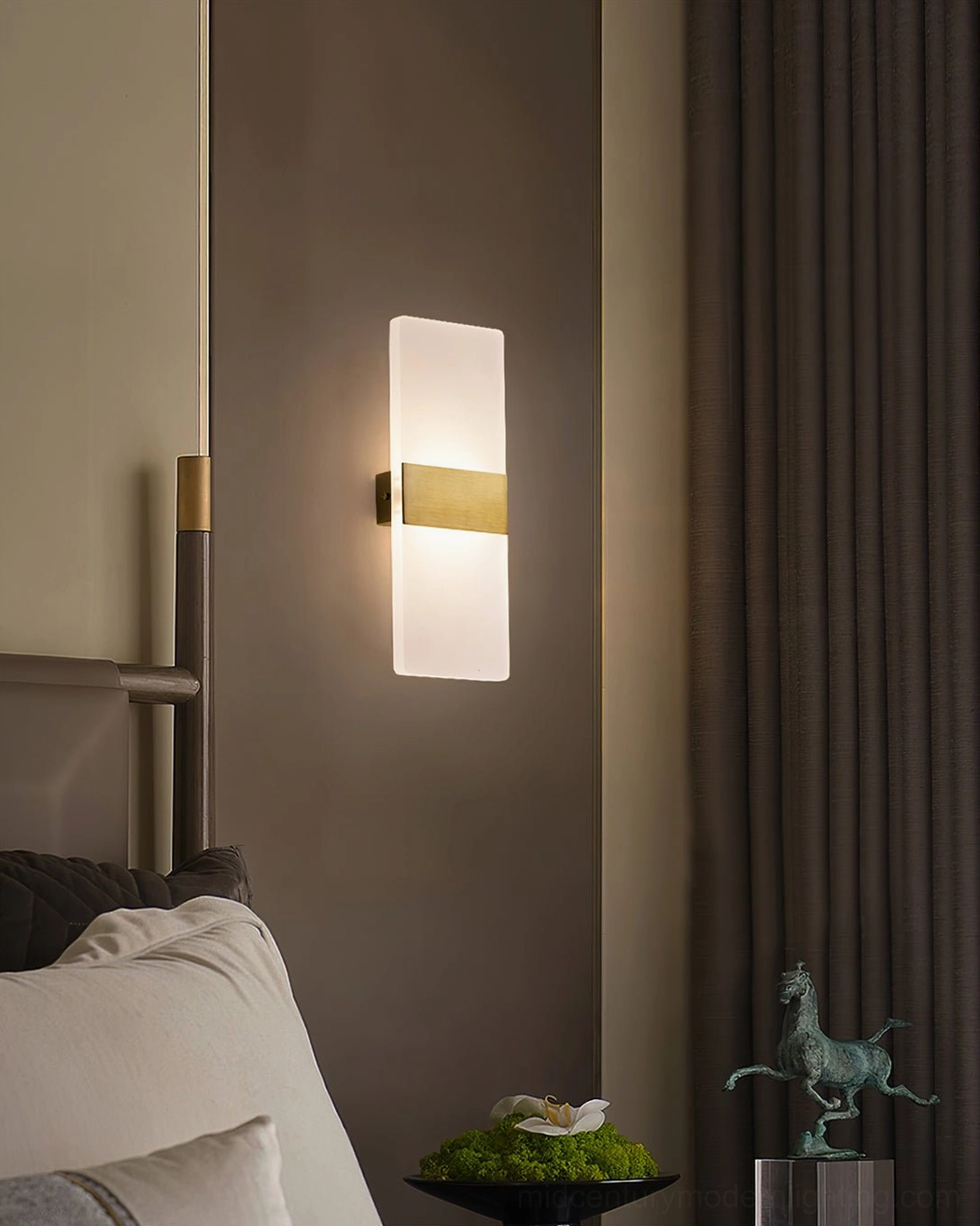 Vertical wall lamp with black metal middle band and frosted white shade in bedroom interior