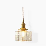 Jewel brass and clear glass pendant light - Model A compact square design with hammered glass shade and brass frame on white studio background