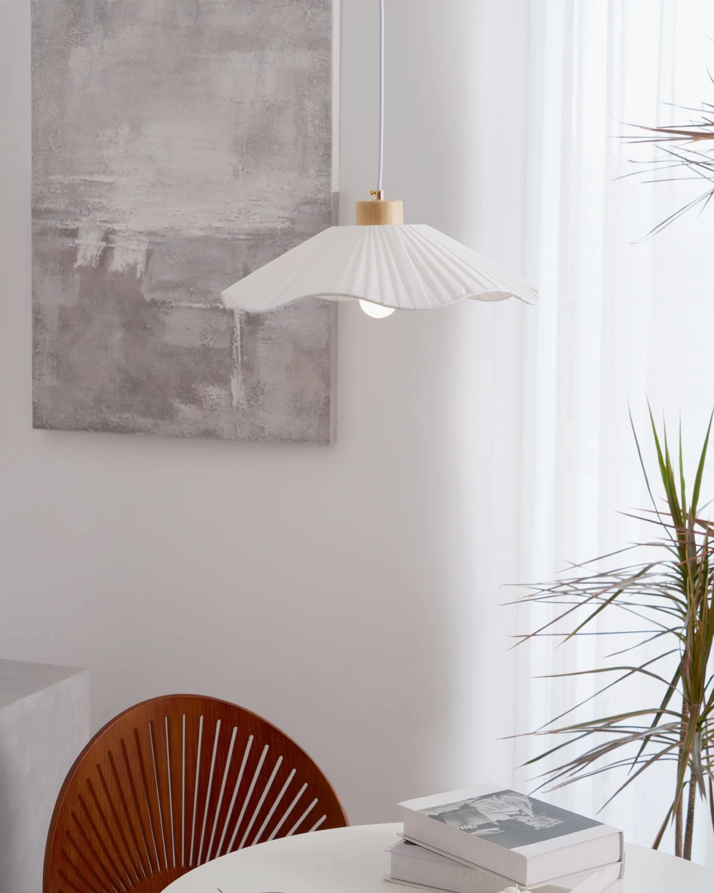 Jimi fabric pendant light installed above minimalist dining table with wooden chairs, modern interior with abstract wall art