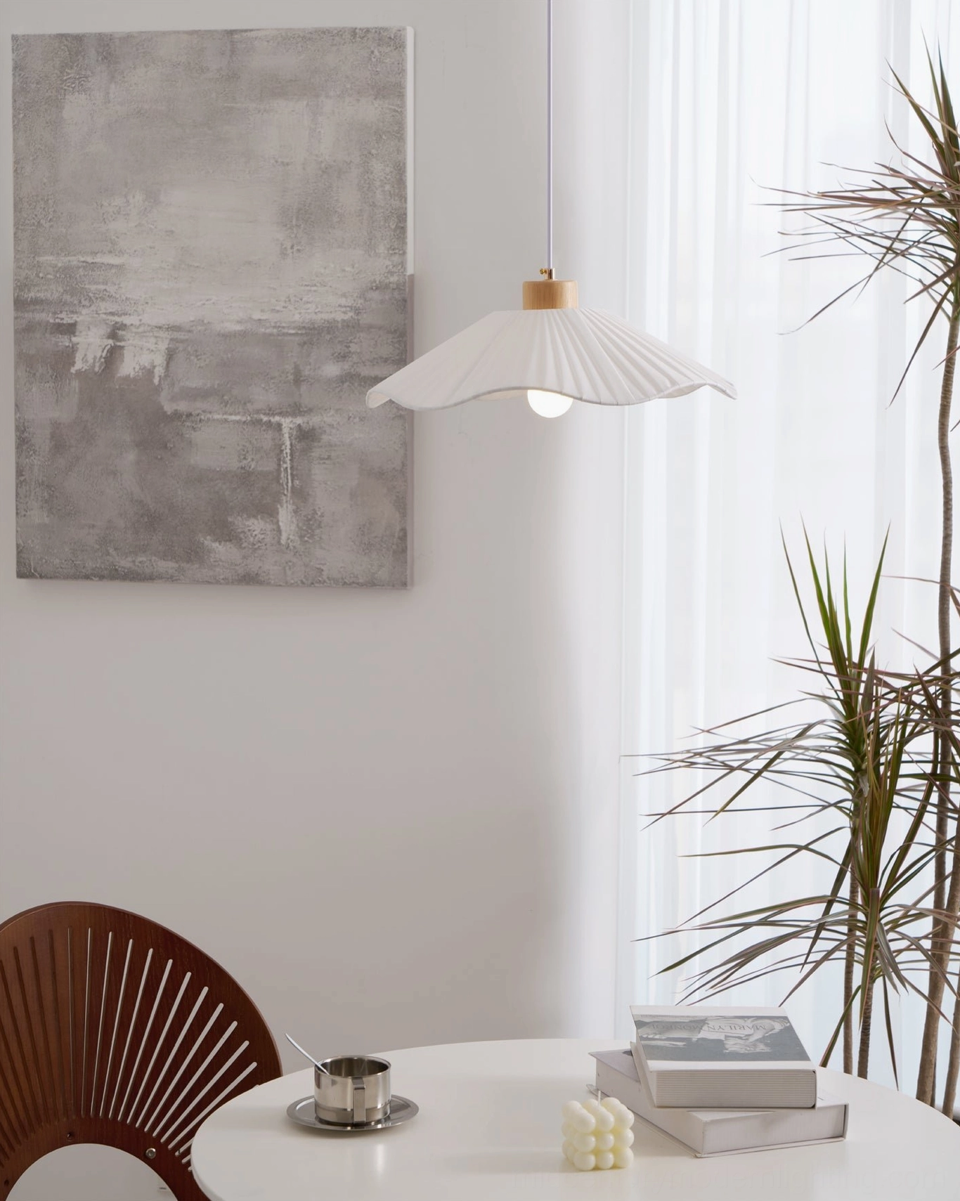 Jimi fabric pendant light in three-quarter view, white pleated shade suspended in minimalist corner with abstract wall decoration