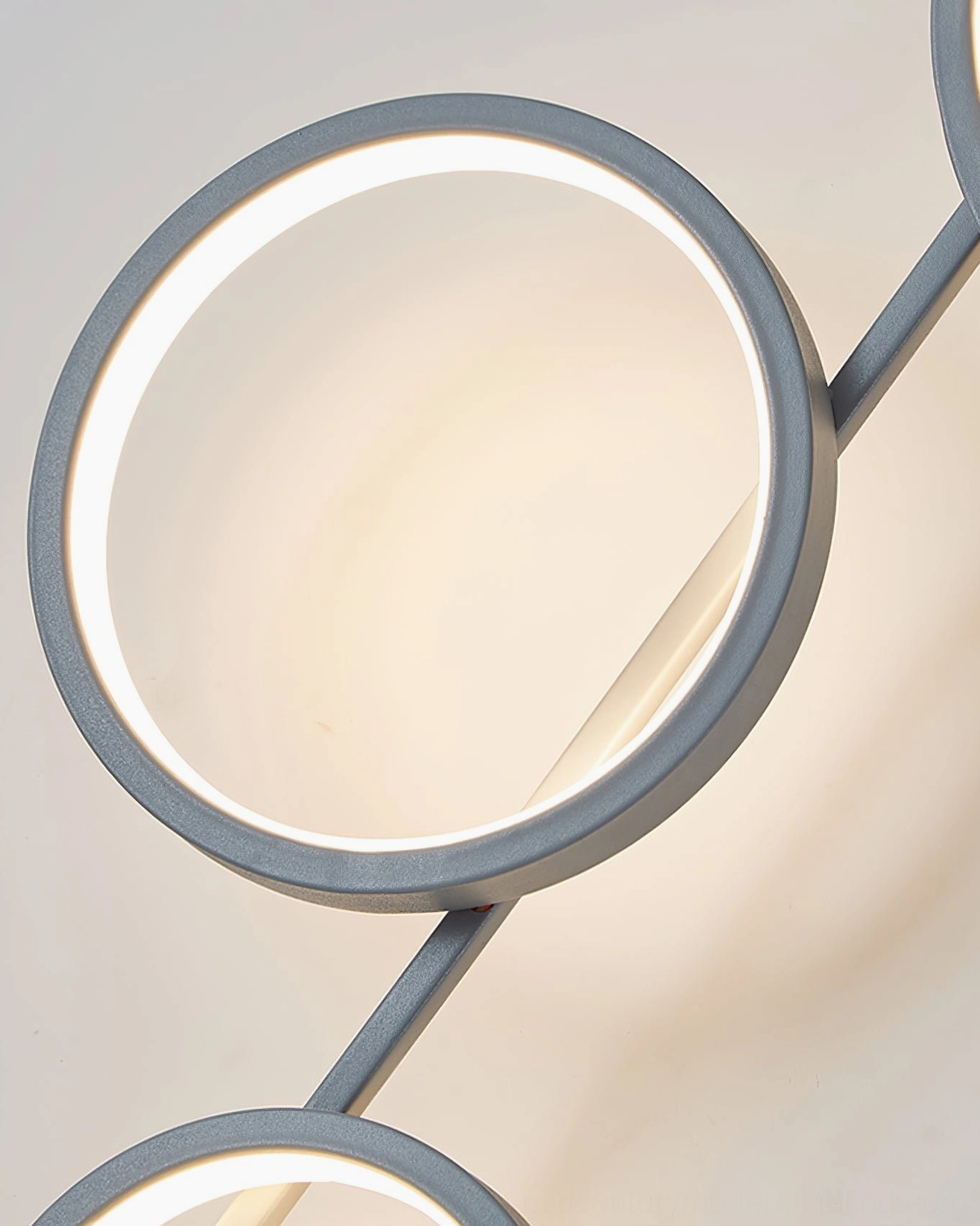 Jocco wall lamp illuminated in cool white light contemporary minimalist bedroom setting