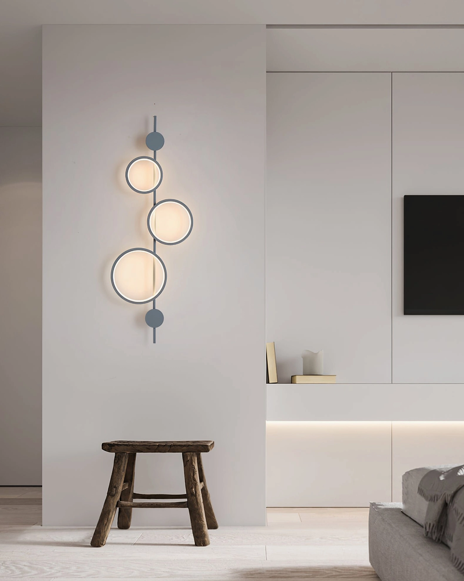 Modern minimalist living room featuring illuminated Jocco wall lamp above fireplace with warm glow