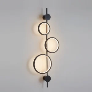 Jocco wall lamp illuminated in warm white light - black finish showing indirect ambient glow on wall
