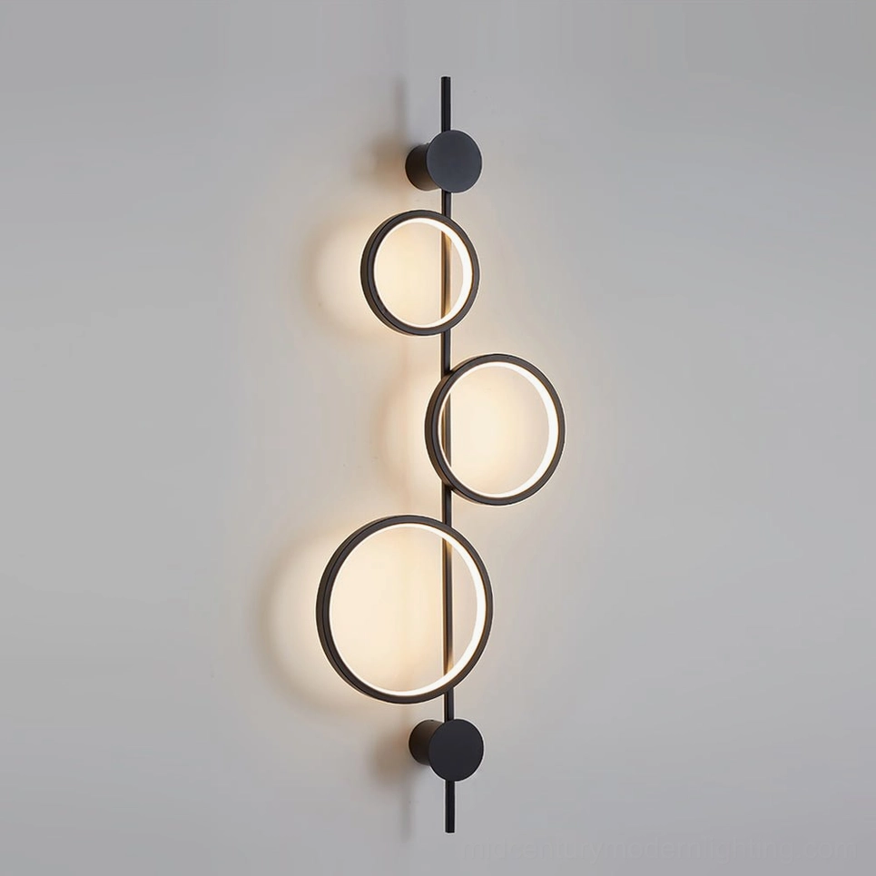 Jocco wall lamp illuminated in warm white light - black finish showing indirect ambient glow on wall