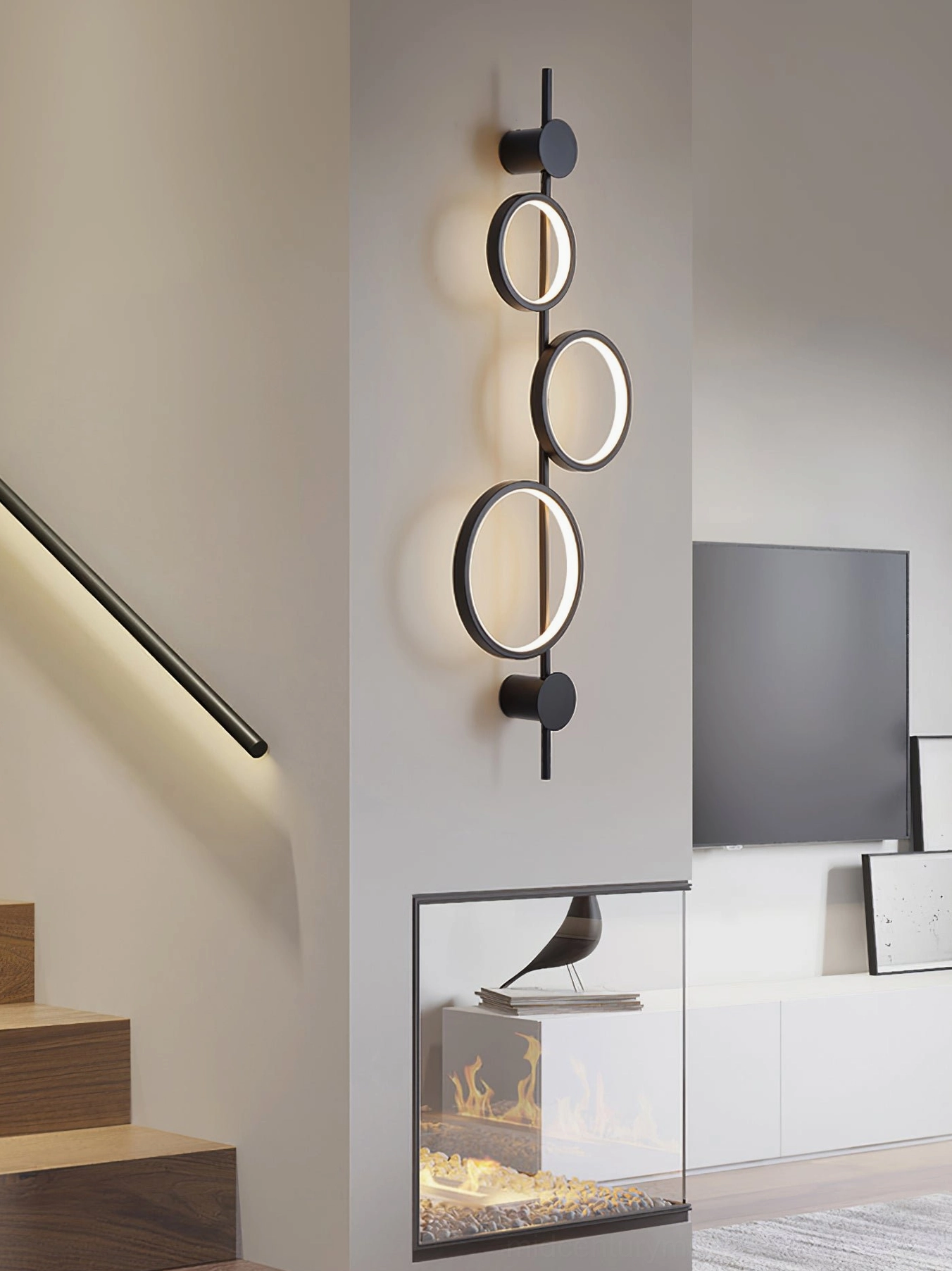 Illuminated Jocco wall lamp in staircase living room creating sculptural shadow patterns on wall