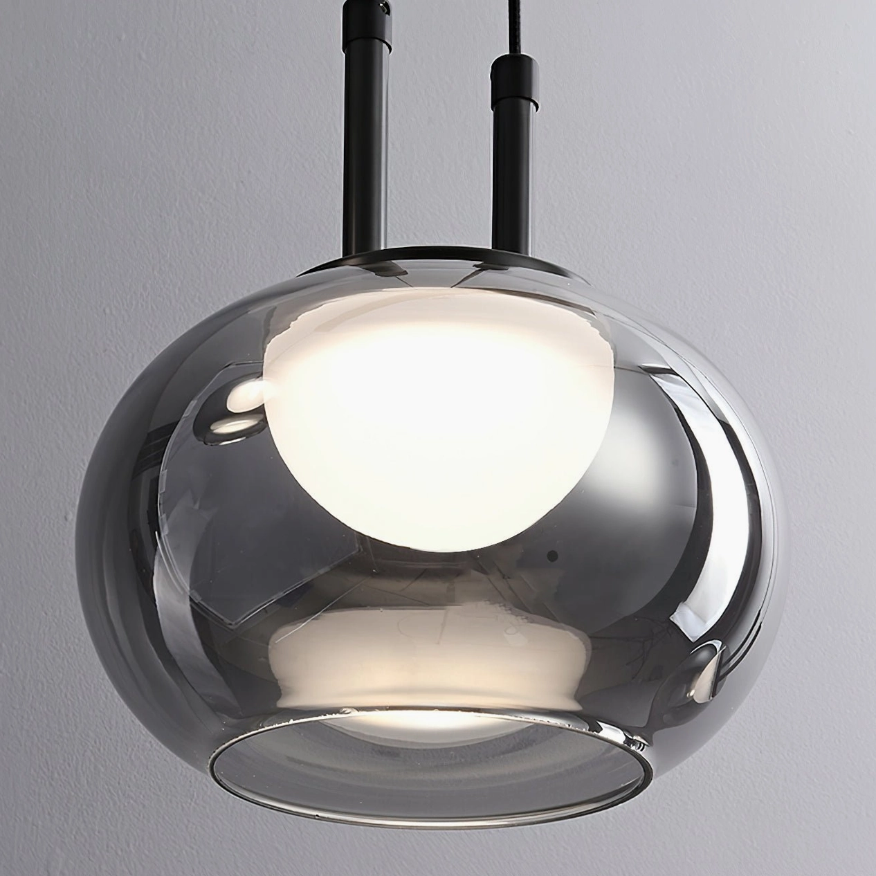 Low-angle close-up of Johan pendant glass shade with warm LED illumination