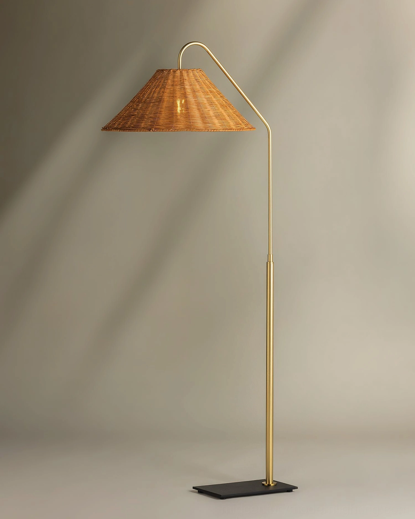 Juno hand-woven rattan cone floor lamp with brass-finished metal arc stem, complete product view