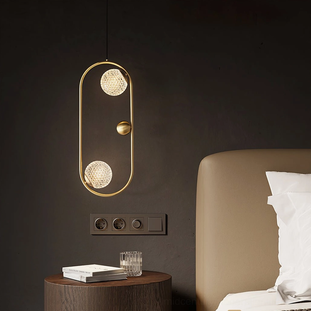 Jupiter pendant light in minimalist hotel-style bedroom, eye-level view showing warm brass finish and geometric glass shade detail