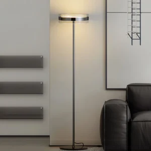 Modern black torchiere floor lamp creating warm ambient lighting in contemporary living room with leather sofa and wall art