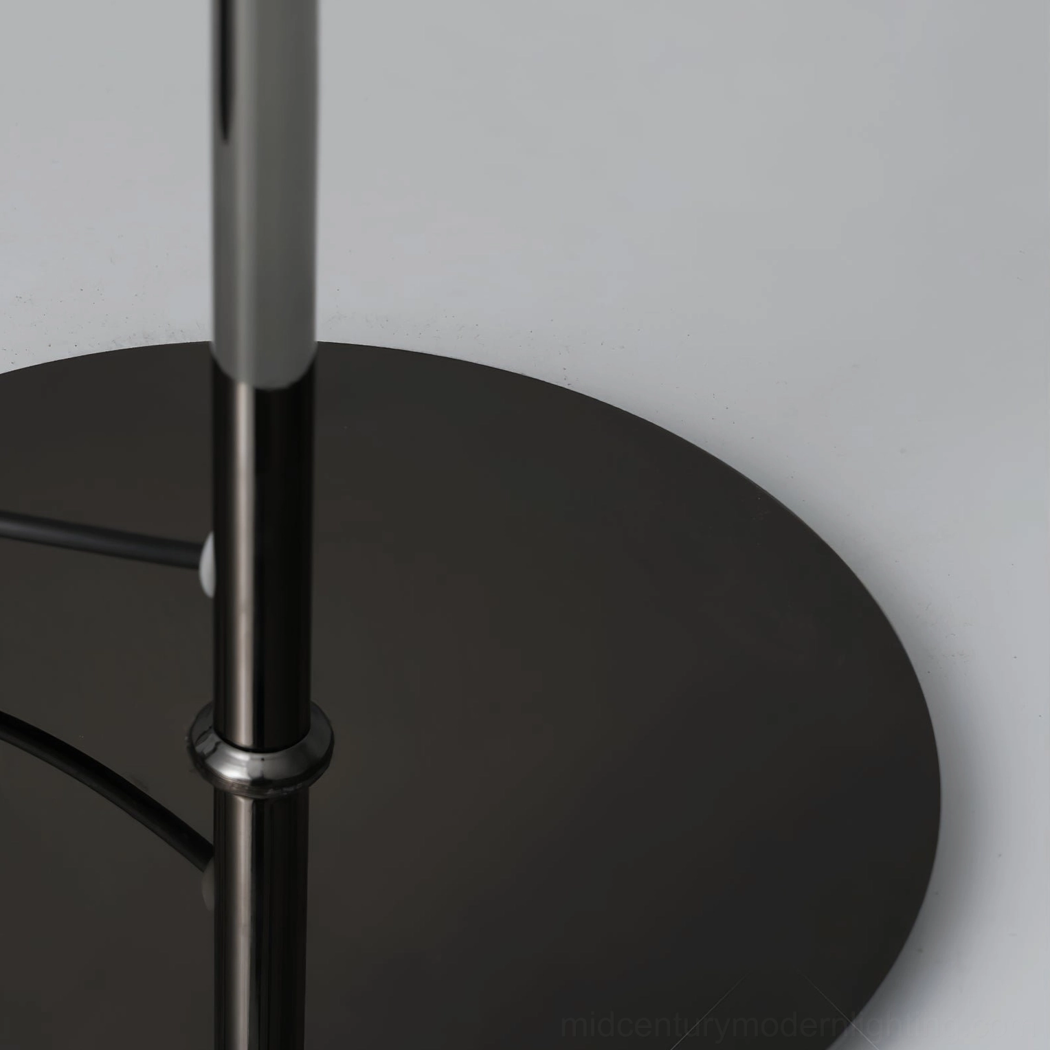 Kaede floor lamp pole and circular base close-up detail showing polished black metal construction and stability design