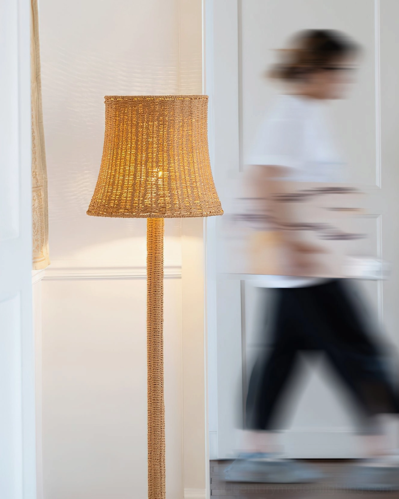 Kakasi handwoven rattan floor lamp with tapered shade in living room with floral wall decor
