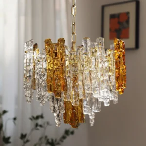 Kalmar dual-tone ice glass pendant chandelier hanging in warm living room with amber and clear layered glass creating ambient light