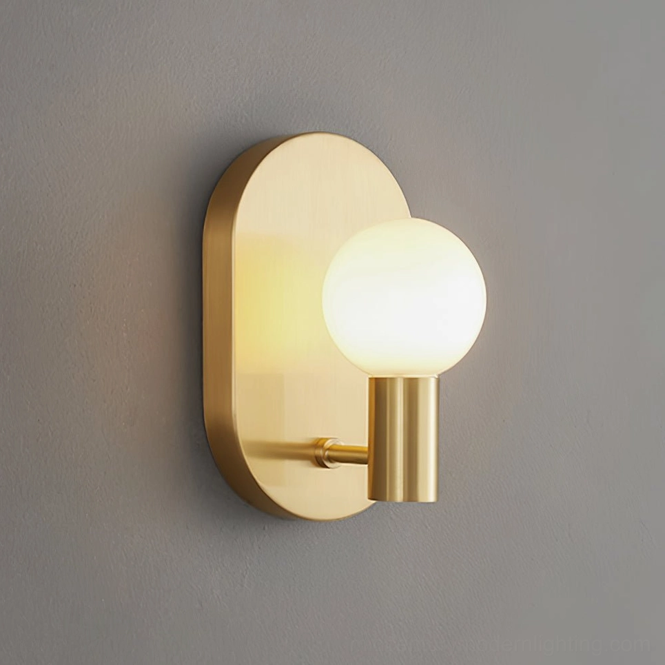 Kalux brass wall lamp with warm gold finish and glowing frosted glass bulb close-up side angle