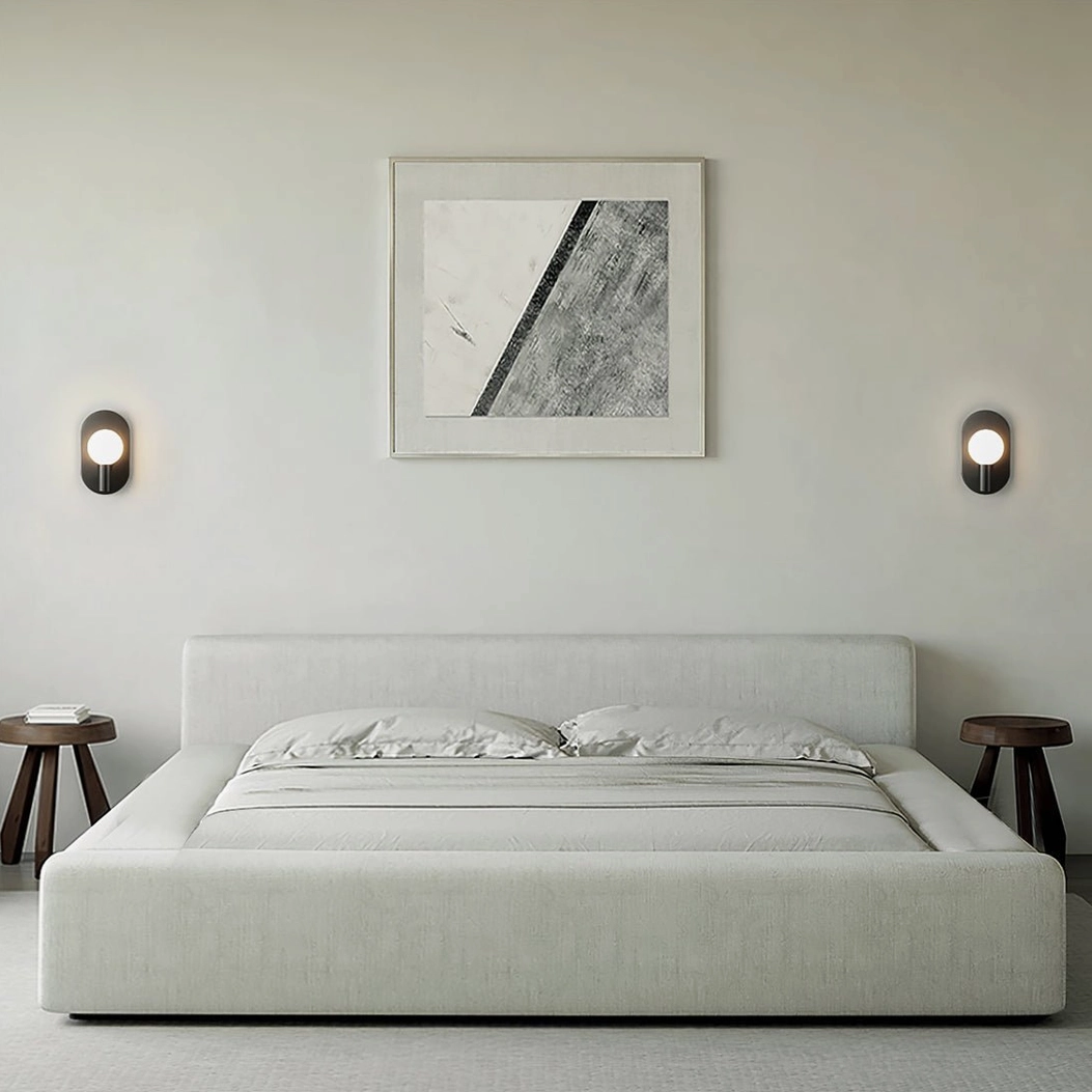 Kalux wall lamp brass finish with warm ambient glow from frosted glass sphere bulb