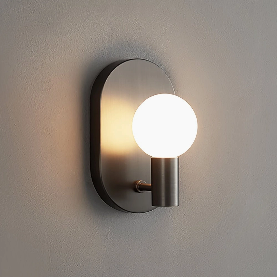 Kalux matte black wall sconce with oblong metal base mounted on textured gray wall close-up