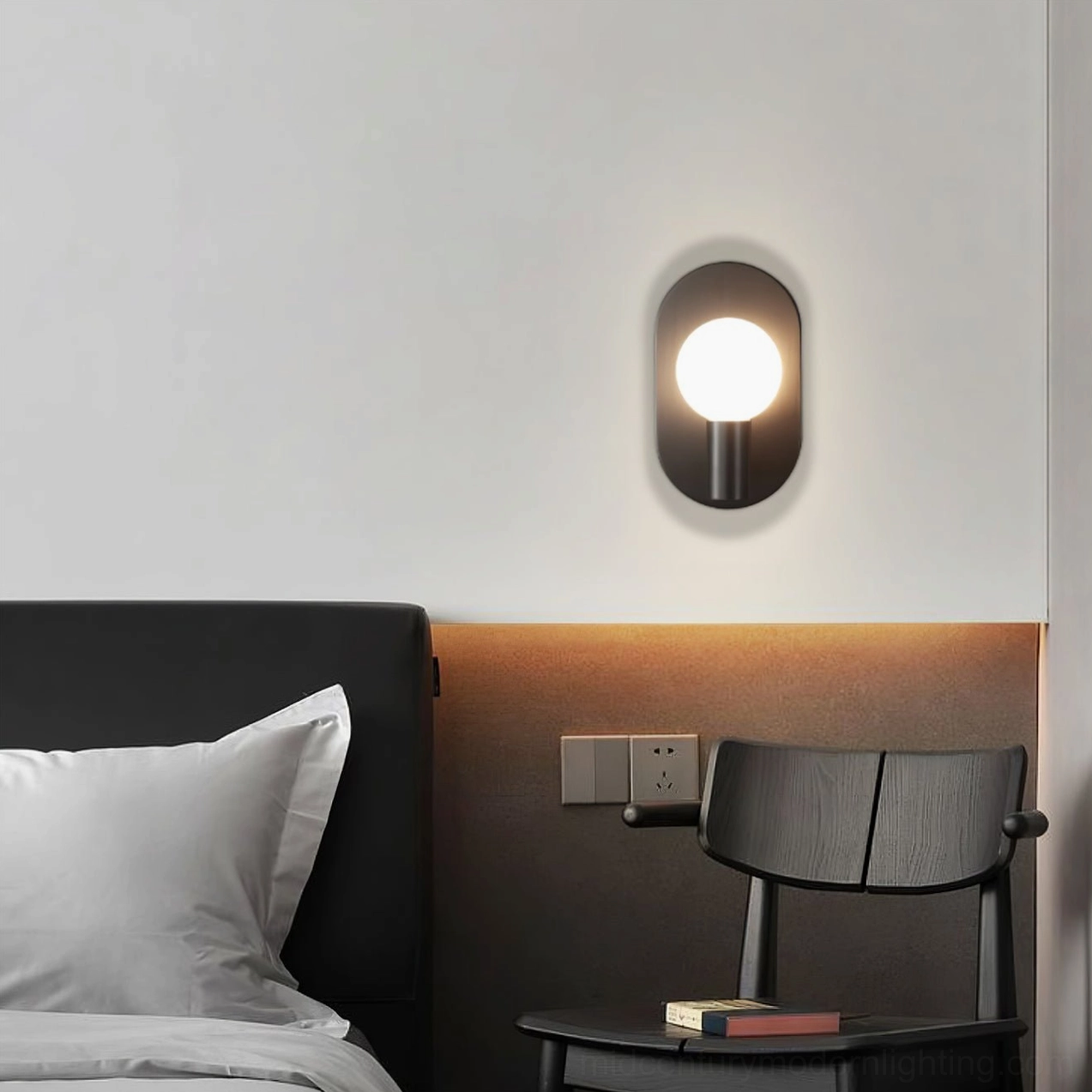 Kalux compact matte black wall lamp providing warm ambient lighting in modern bedroom corner