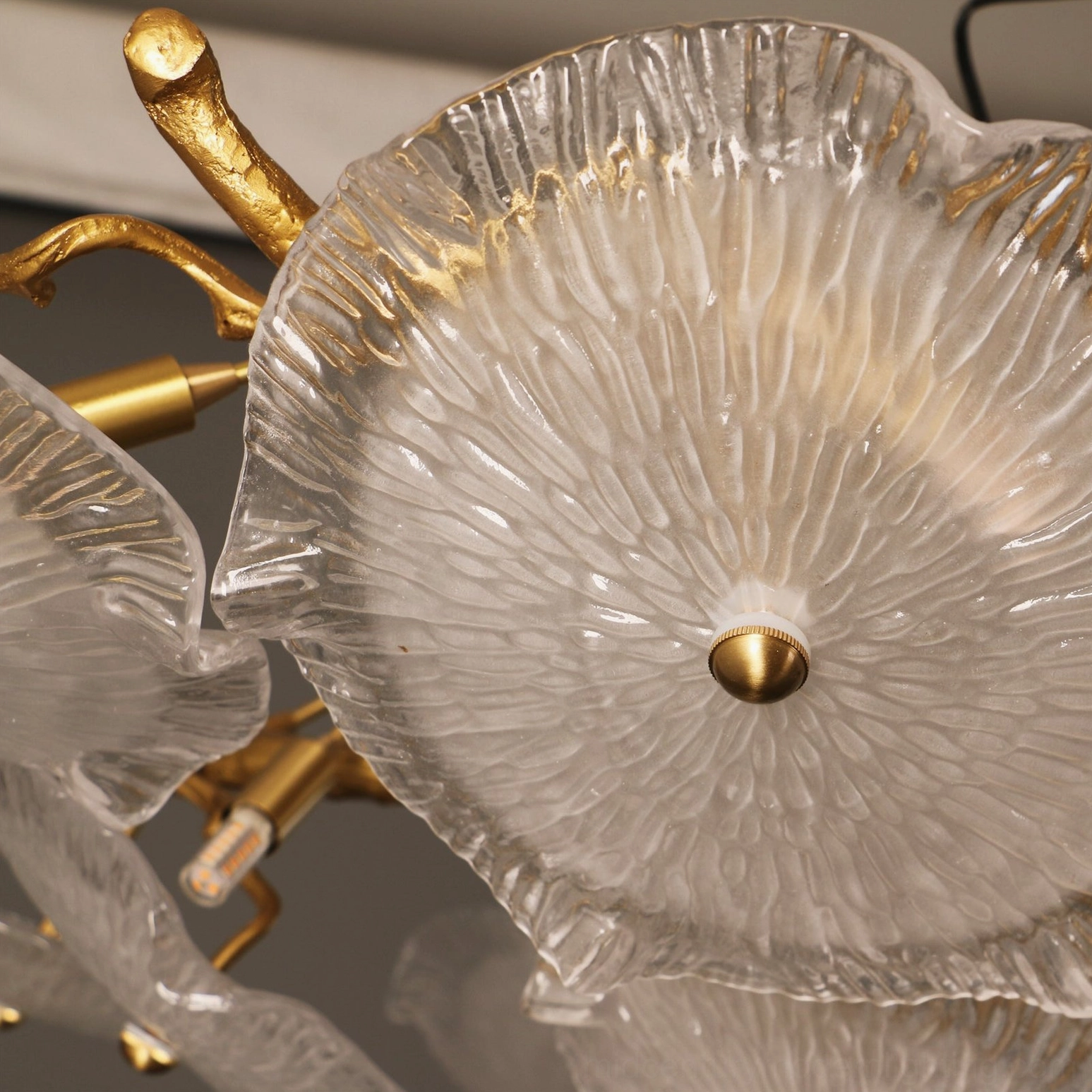 Close-up detail of Kamal ceiling lamp ribbed glass petals with polished brass hardware