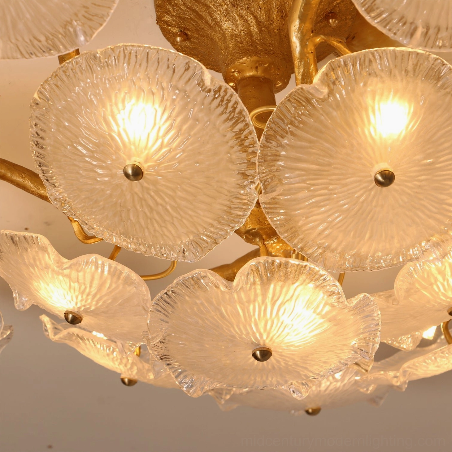 Illuminated Kamal ceiling lamp close-up showing glowing ribbed glass and gold metal fixtures