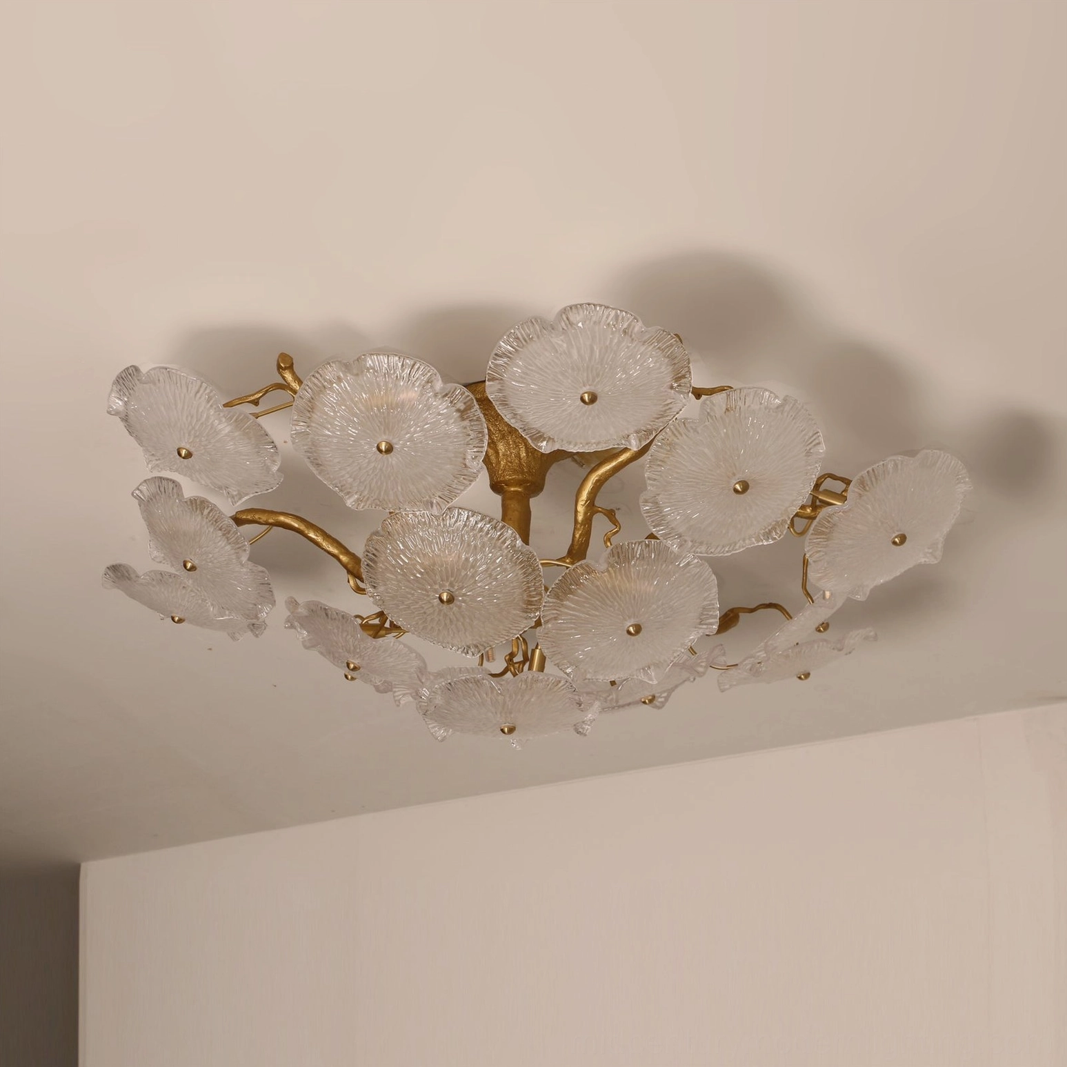 Unlit Kamal flush mount lamp with frosted glass shades and gold metal branch frame, minimalist interior