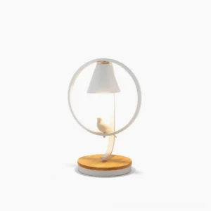 Kamilah modern table lamp with circular white metal frame and bird ornament on natural wood base, front view studio photography
