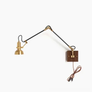 Kane swing arm plug-in wall lamp with brass articulating arm and walnut wood wall plate, fully extended position, front view against white background