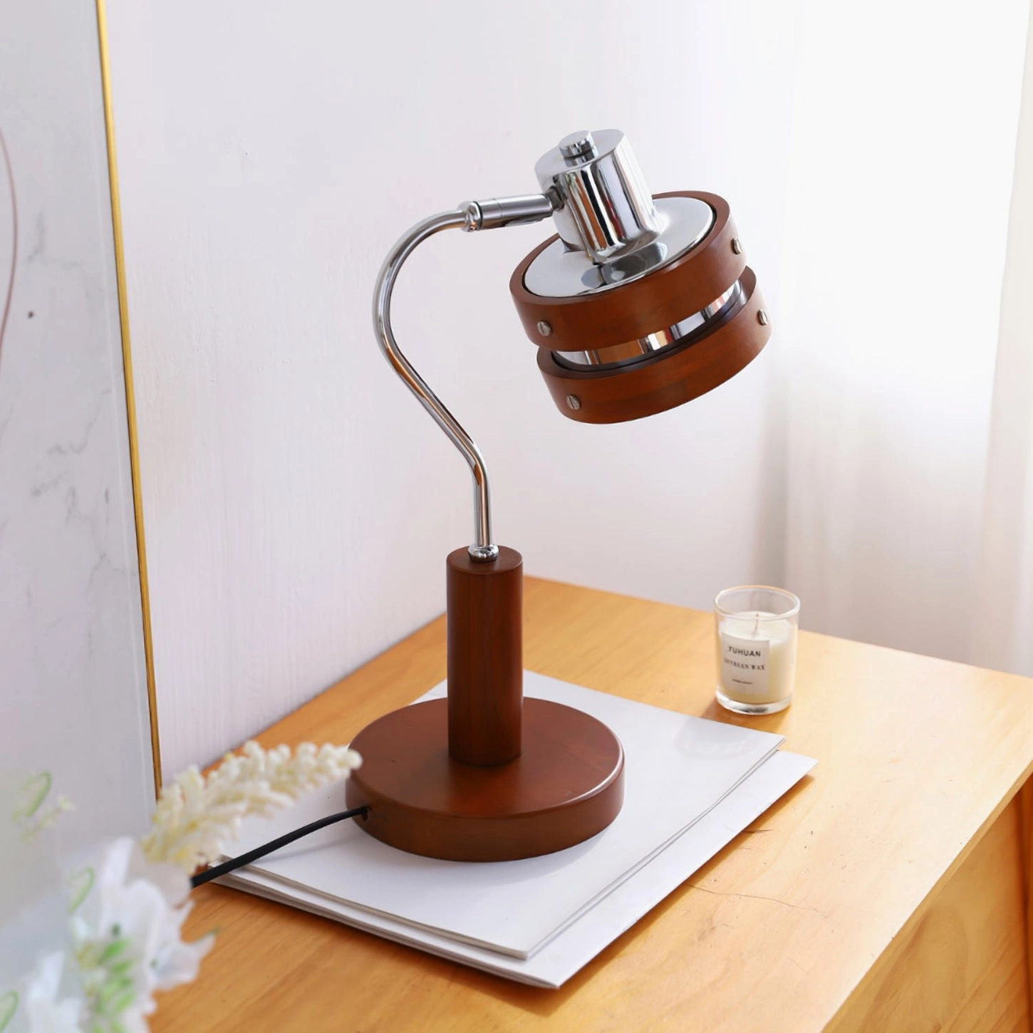 Mid-century modern desk lamp with tilted metal head on floral-decorated side table