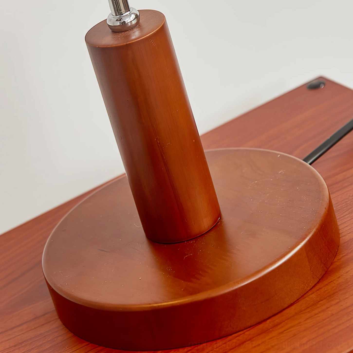 Modern mid-century table lamp with walnut base in styled interior design setting