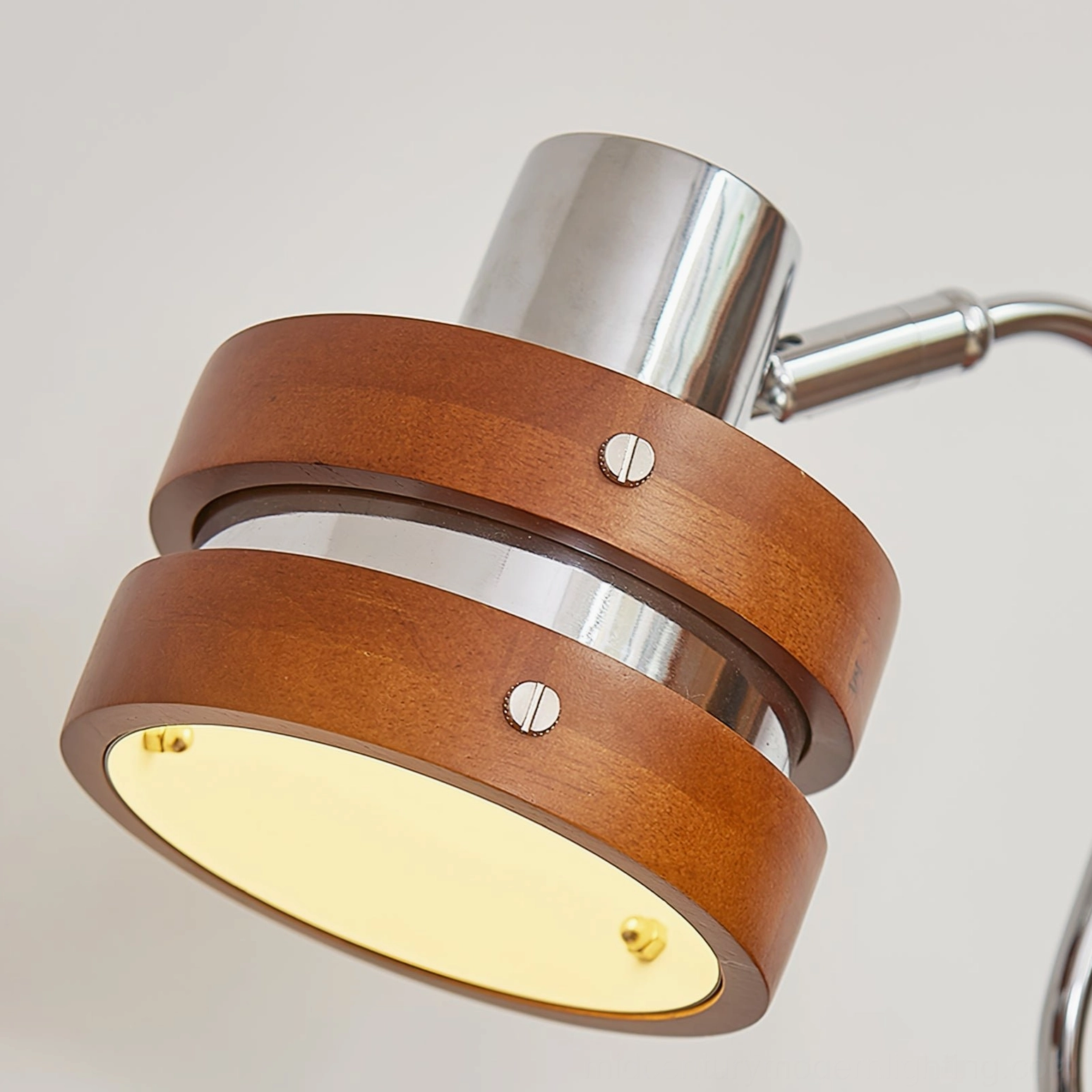 Modern walnut and chrome table lamp showing swivel functionality and design versatility