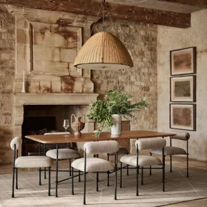 Kash woven rattan pendant light hanging in rustic farmhouse dining room with stone fireplace
