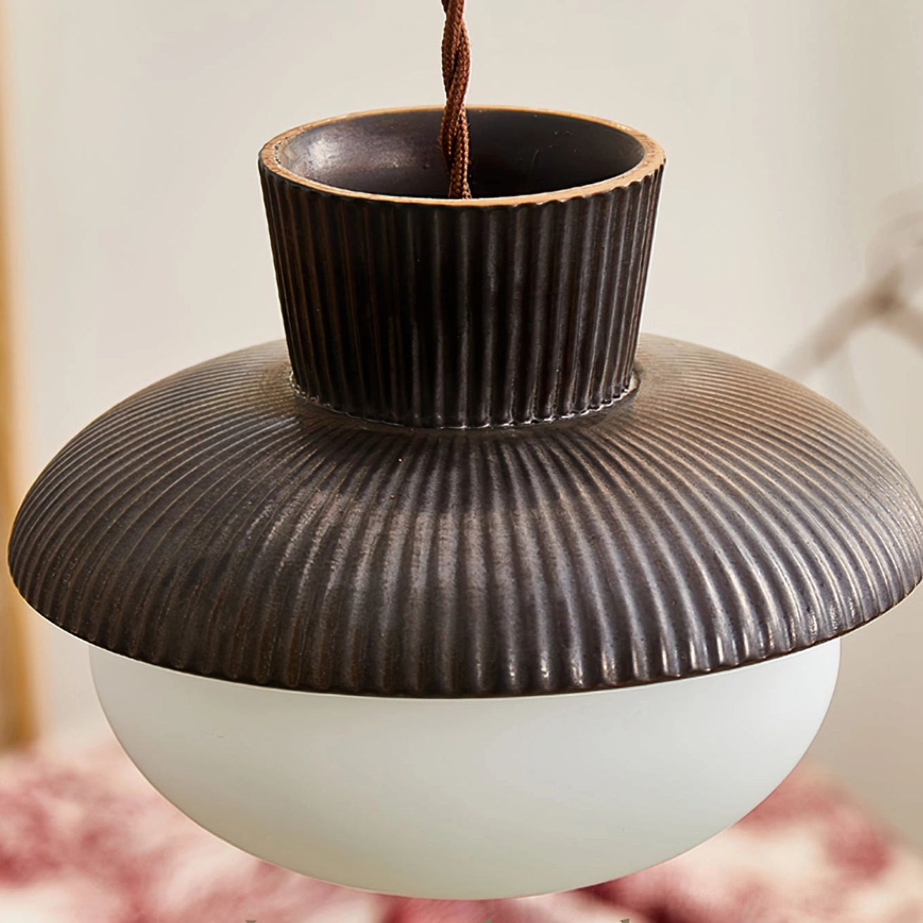 Close-up detail of Kaskad pendant lamp ceramic ribbed top section, overhead macro view showing vertical texture pattern and craftsmanship