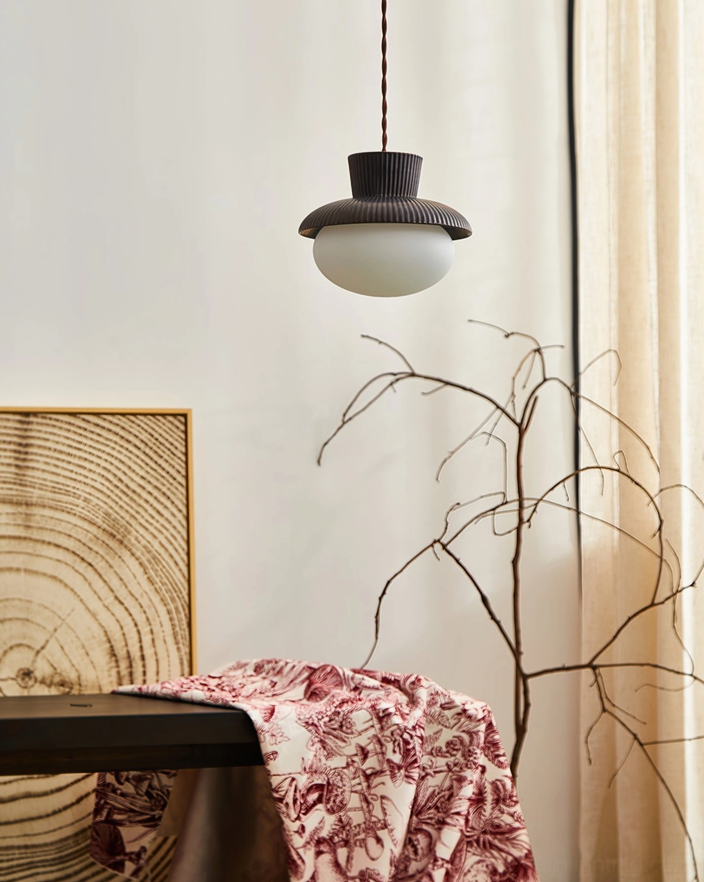 Compact frosted glass Kaskad pendant lamp, distant side view in cozy home decor scene demonstrating scaled proportions and minimalist profile